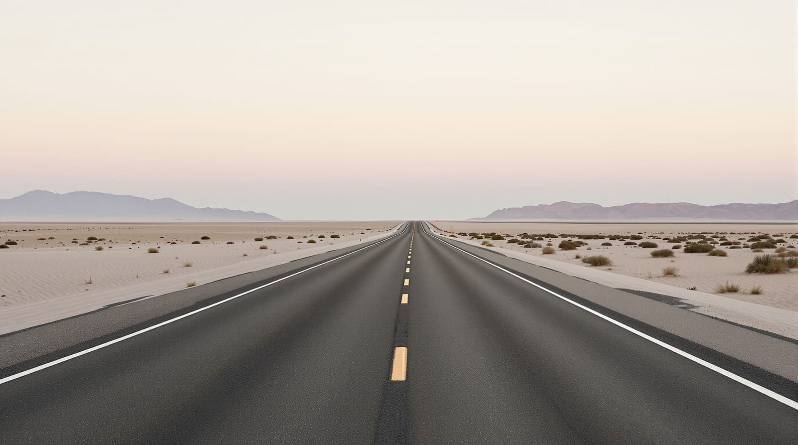 Illustration of an empty desert highway stretching toward distant hazed ridgelines under a pale overcast dawn sky.