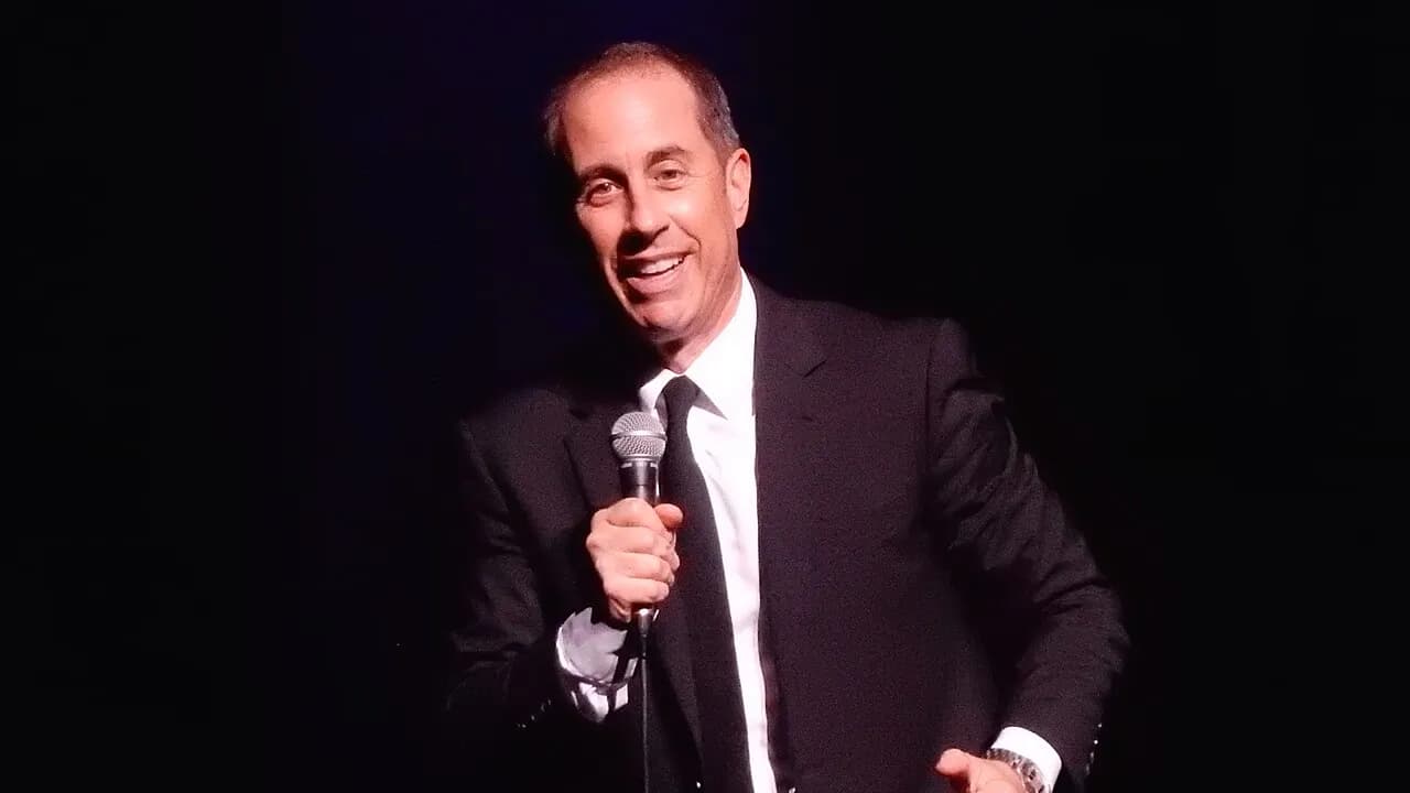 Jerry Seinfeld smiling with a microphone at the Beacon Theatre in New York, 2019