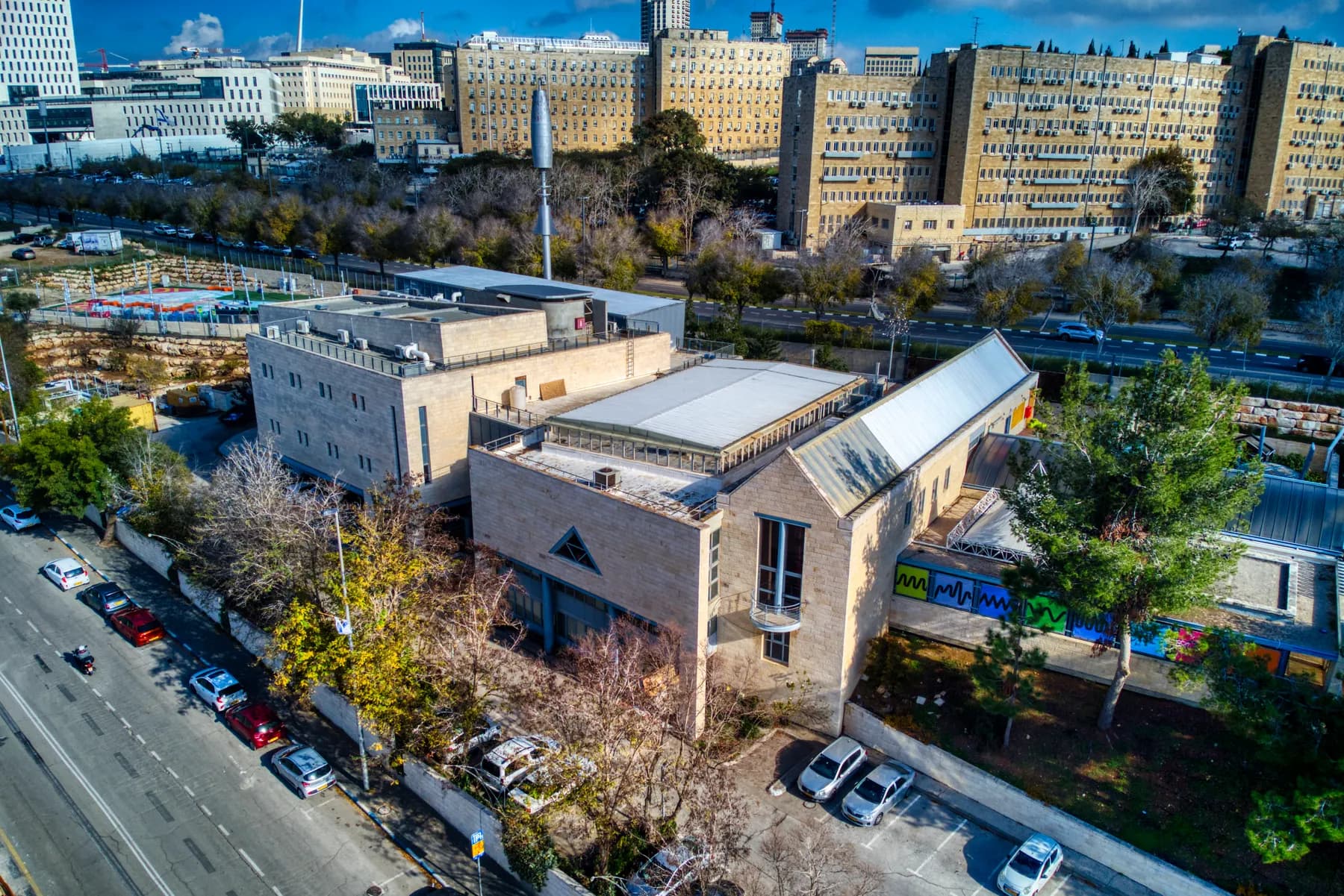 The Bloomfield Science Museum from above, its stone buildings beside a car park, with university buildings behind