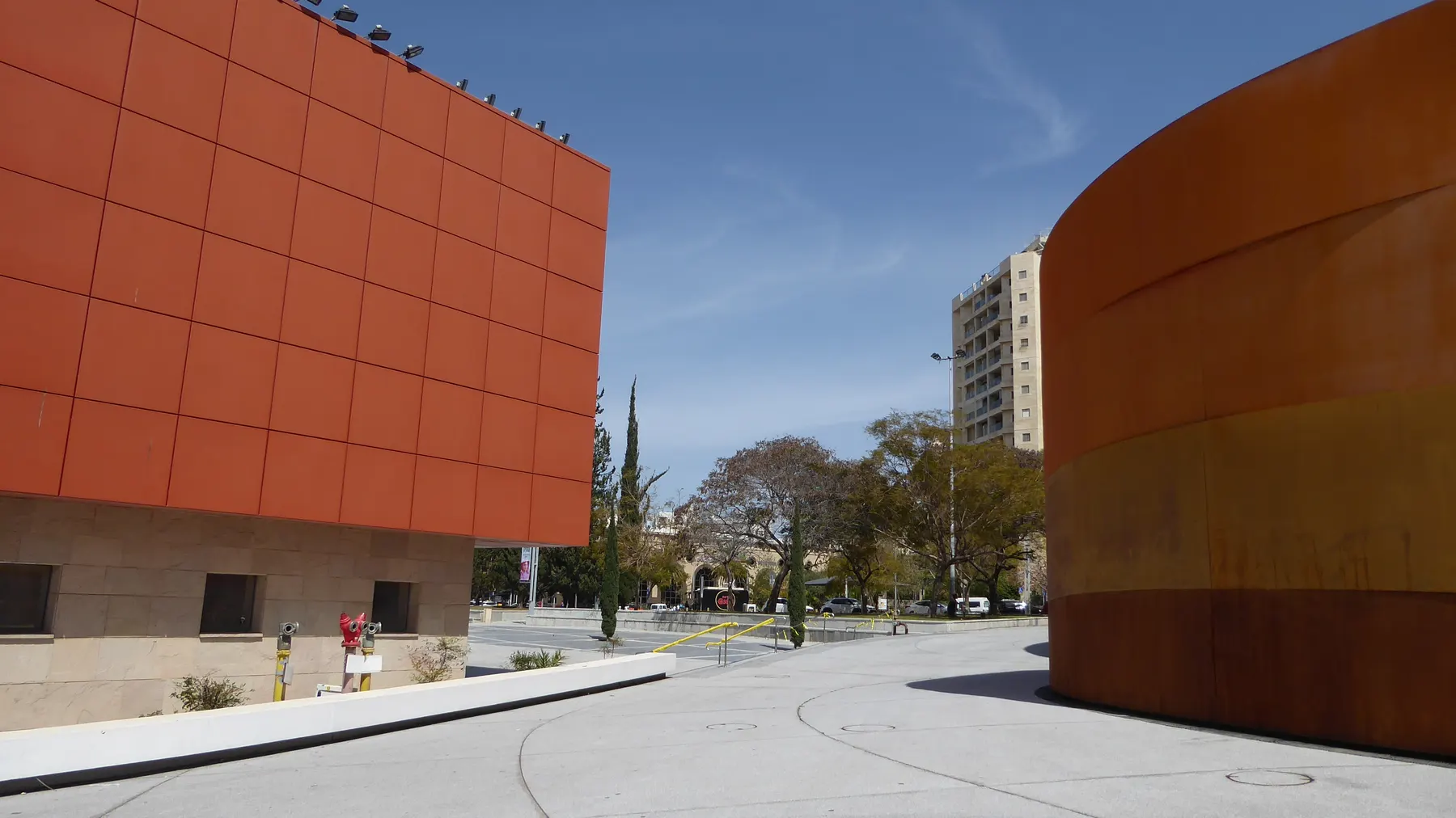 The curving bands of rust-red steel on the Design Museum Holon, against the sky