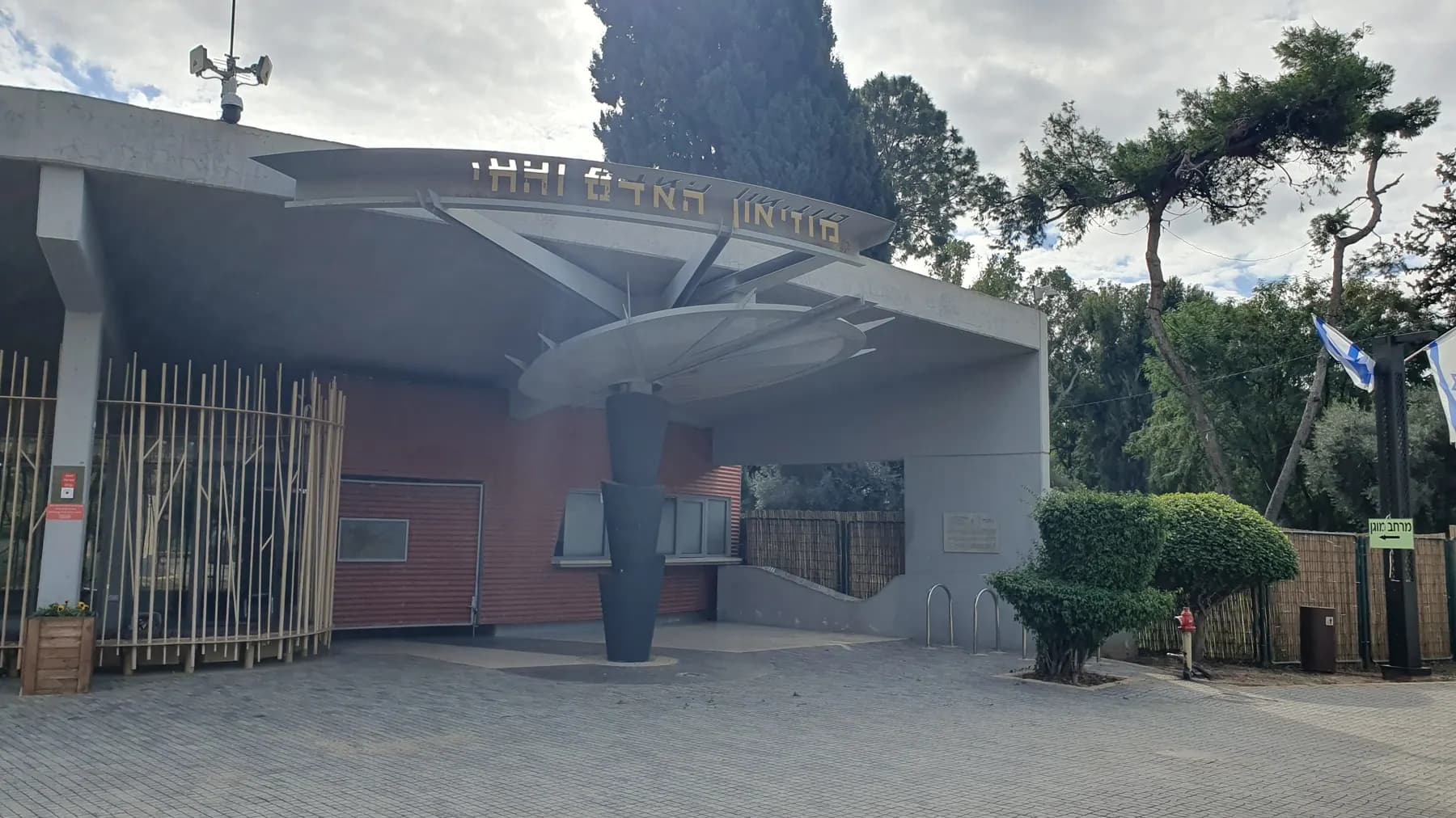 The entrance canopy of the Man and the Living World Museum in Ramat Gan, among pine trees