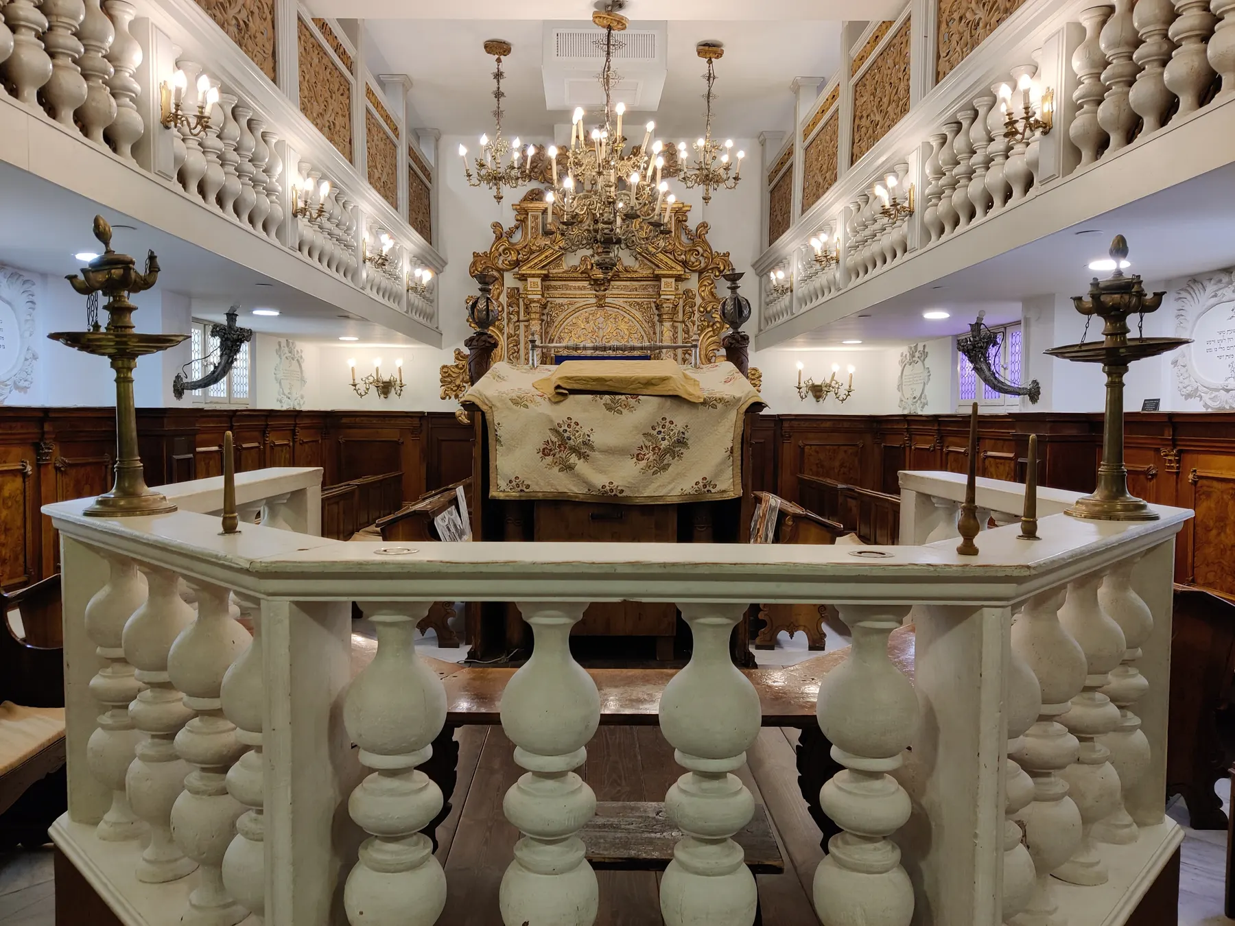 The carved Torah ark and wooden pews of the Italian synagogue in the Nahon Museum of Italian Jewish Art