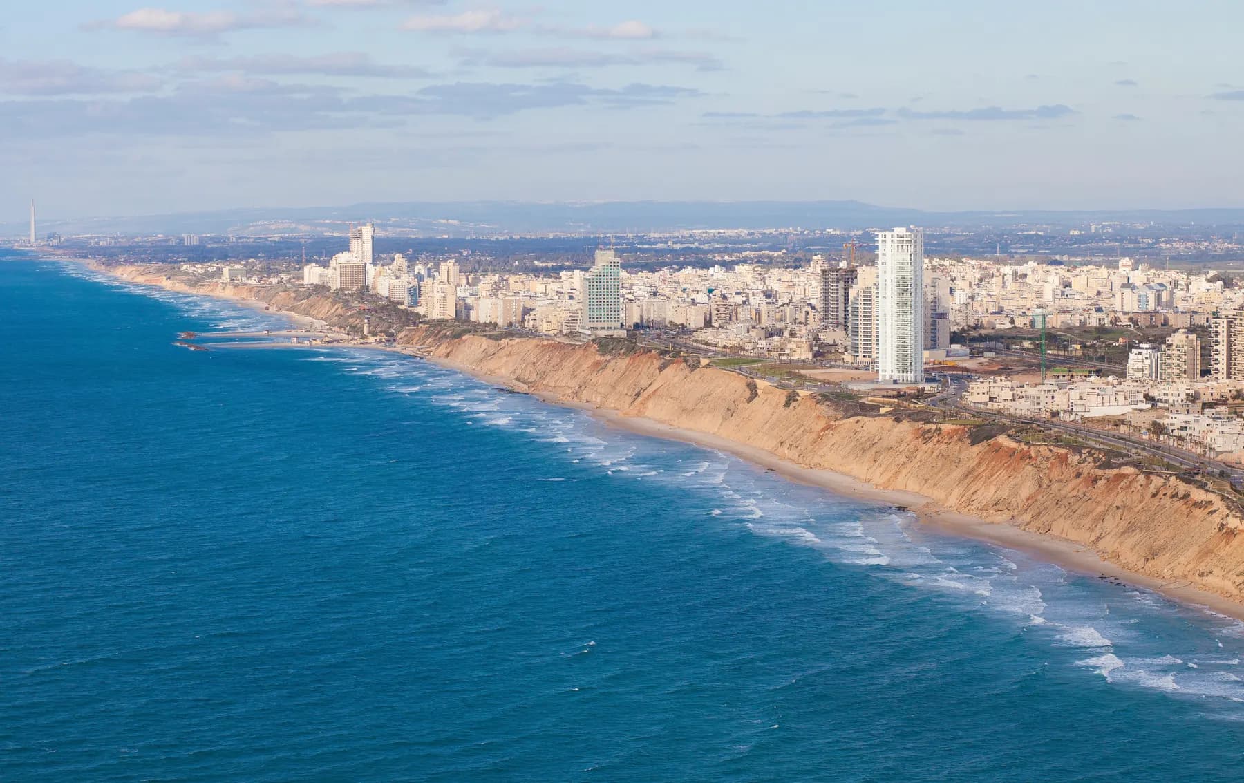 Netanya from the air: a long line of sandstone cliffs and beach below the city's tower blocks