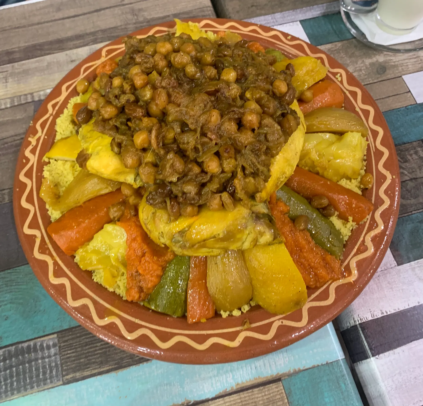 Couscous with chickpeas and vegetables, served Moroccan style in a clay dish