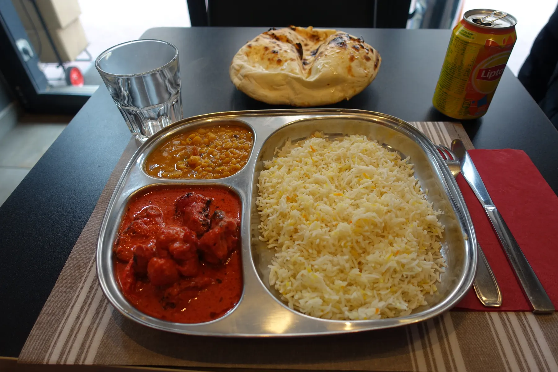 Chicken curry, dal and rice on a steel tray, with naan