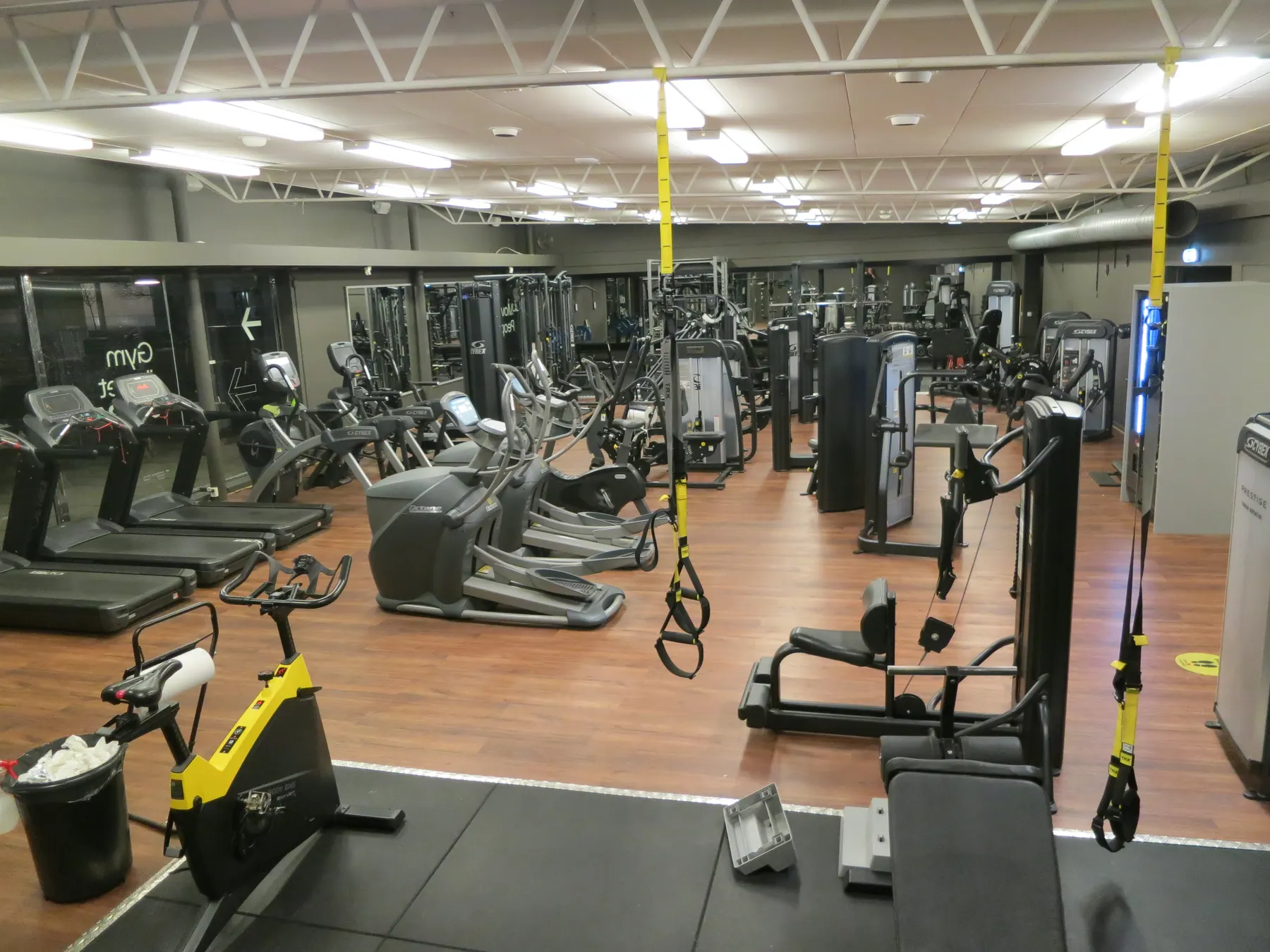 The floor of a gym with treadmills, bikes and weight machines.