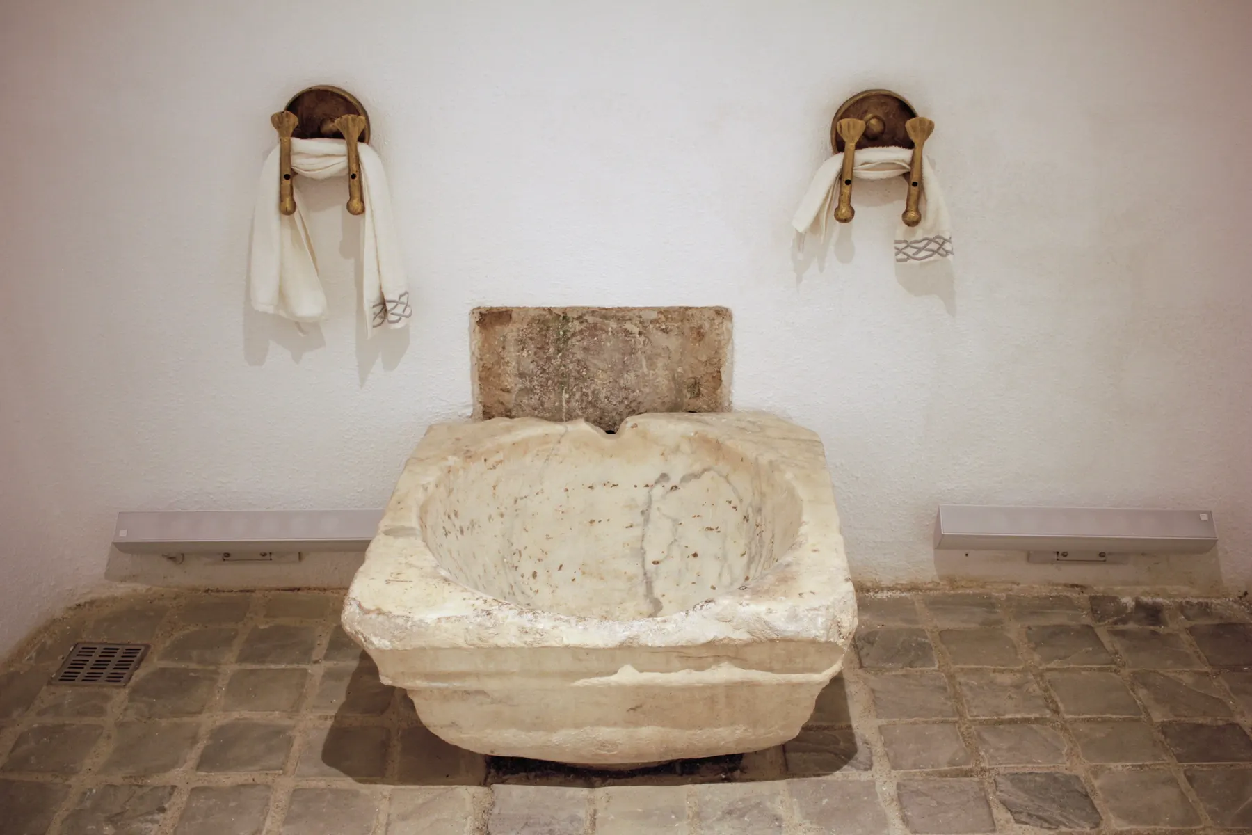 A marble basin and towels in a hammam.