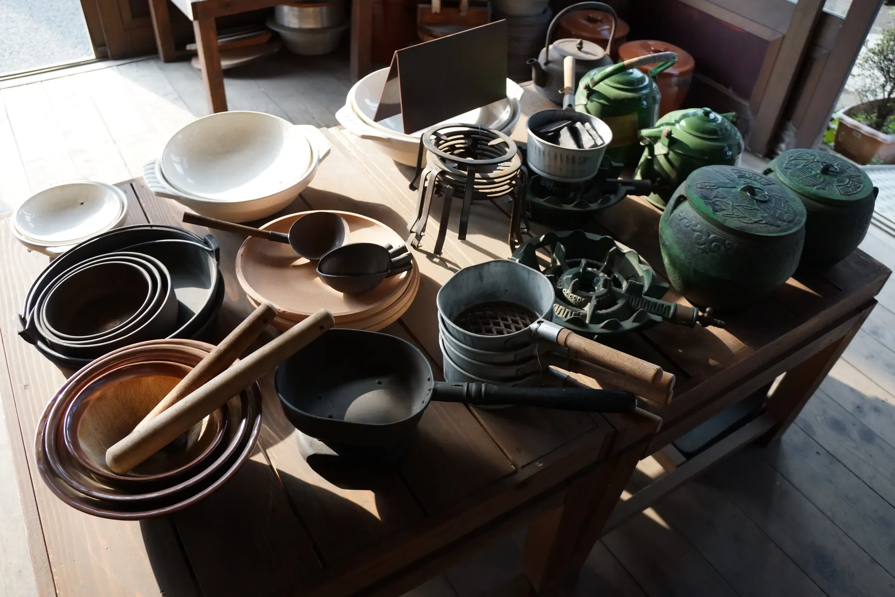 Pots, bowls and kitchenware on a table in a homeware shop.