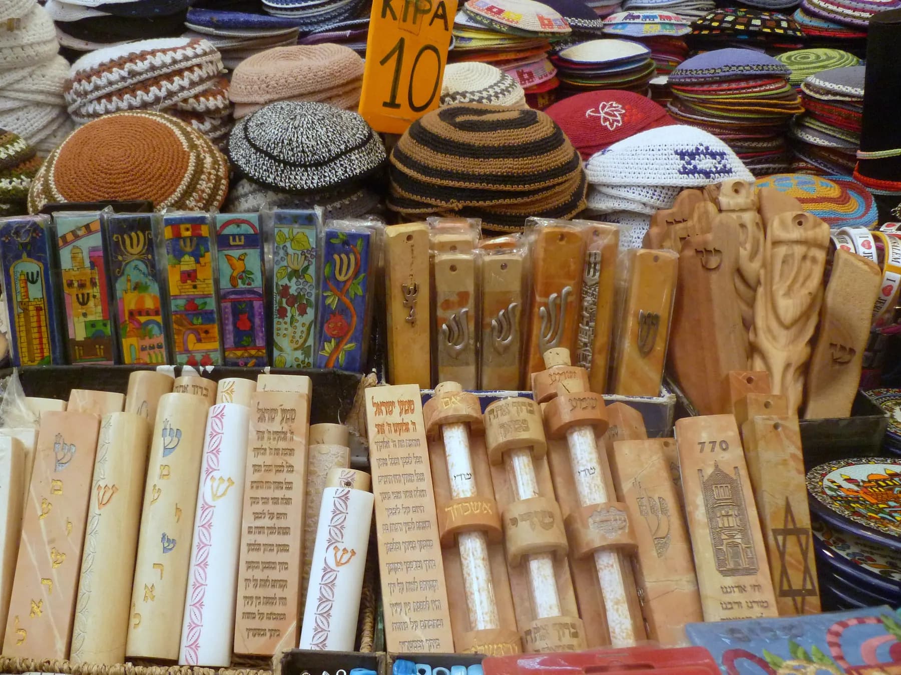 Kippot, mezuzah cases and other Judaica laid out for sale.