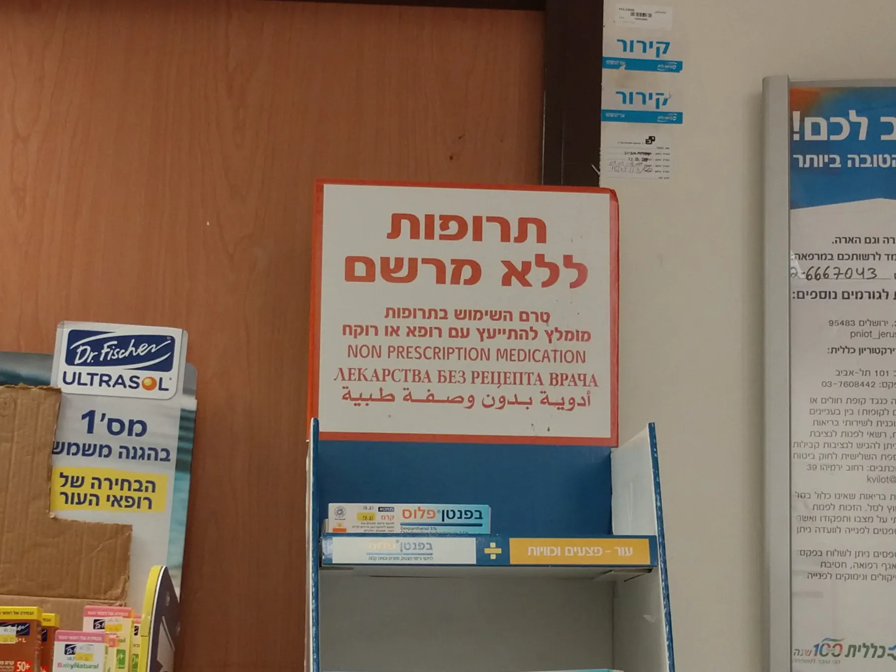 מדף של תרופות ללא מרשם בבית מרקחת, עם שלט בעברית