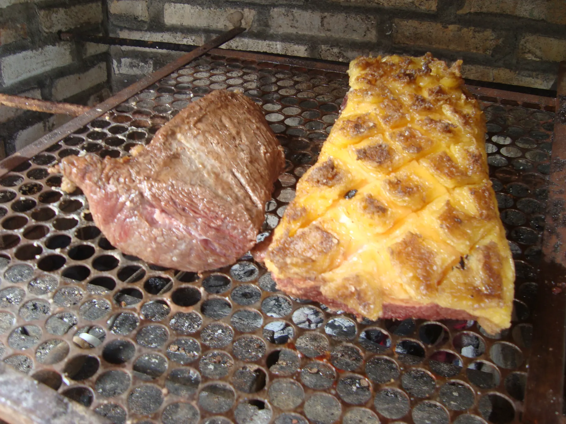 Picanha on a charcoal grill, its fat cap scored