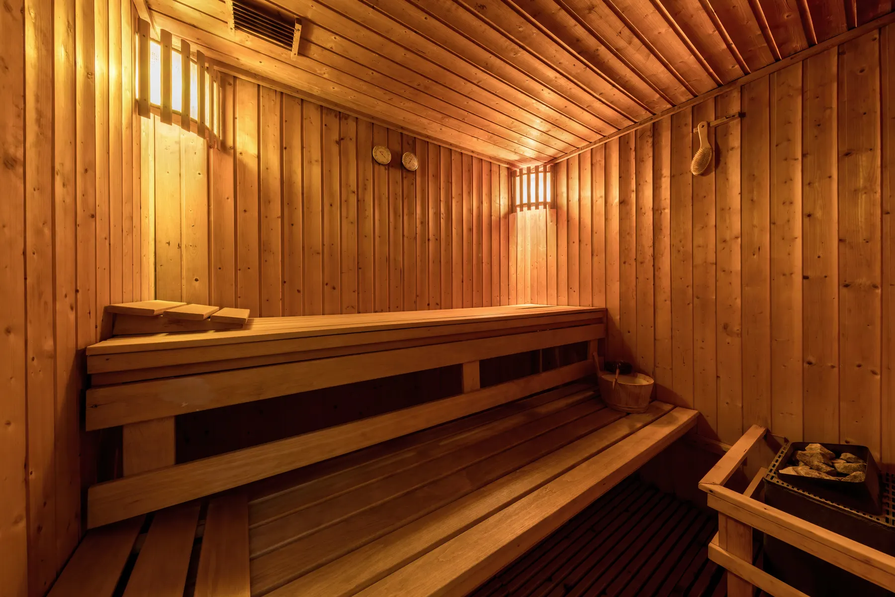 The wooden benches and stove of a sauna.