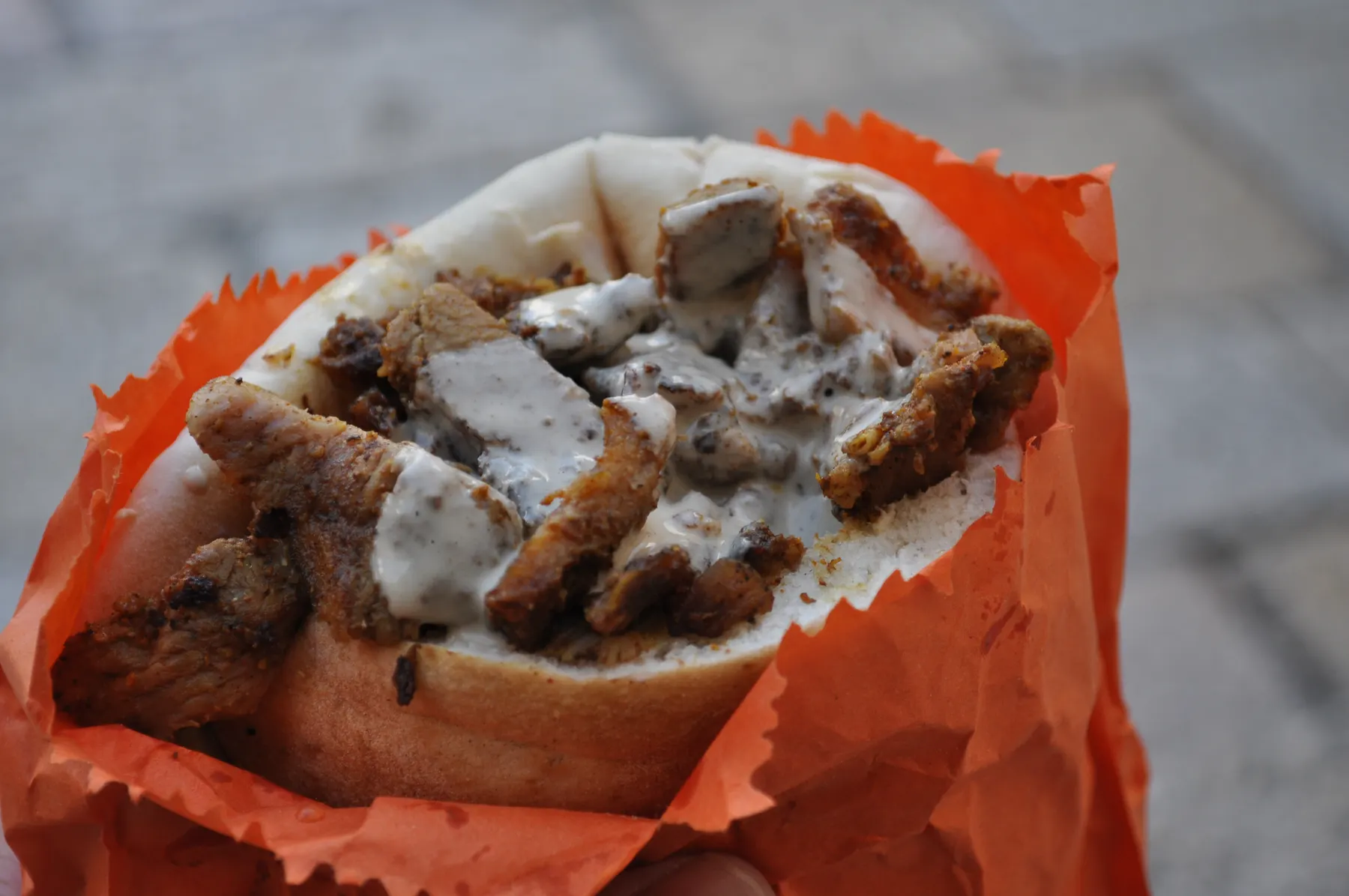 Shawarma sliced into a pita with tahini, in a paper wrapper, in Jerusalem