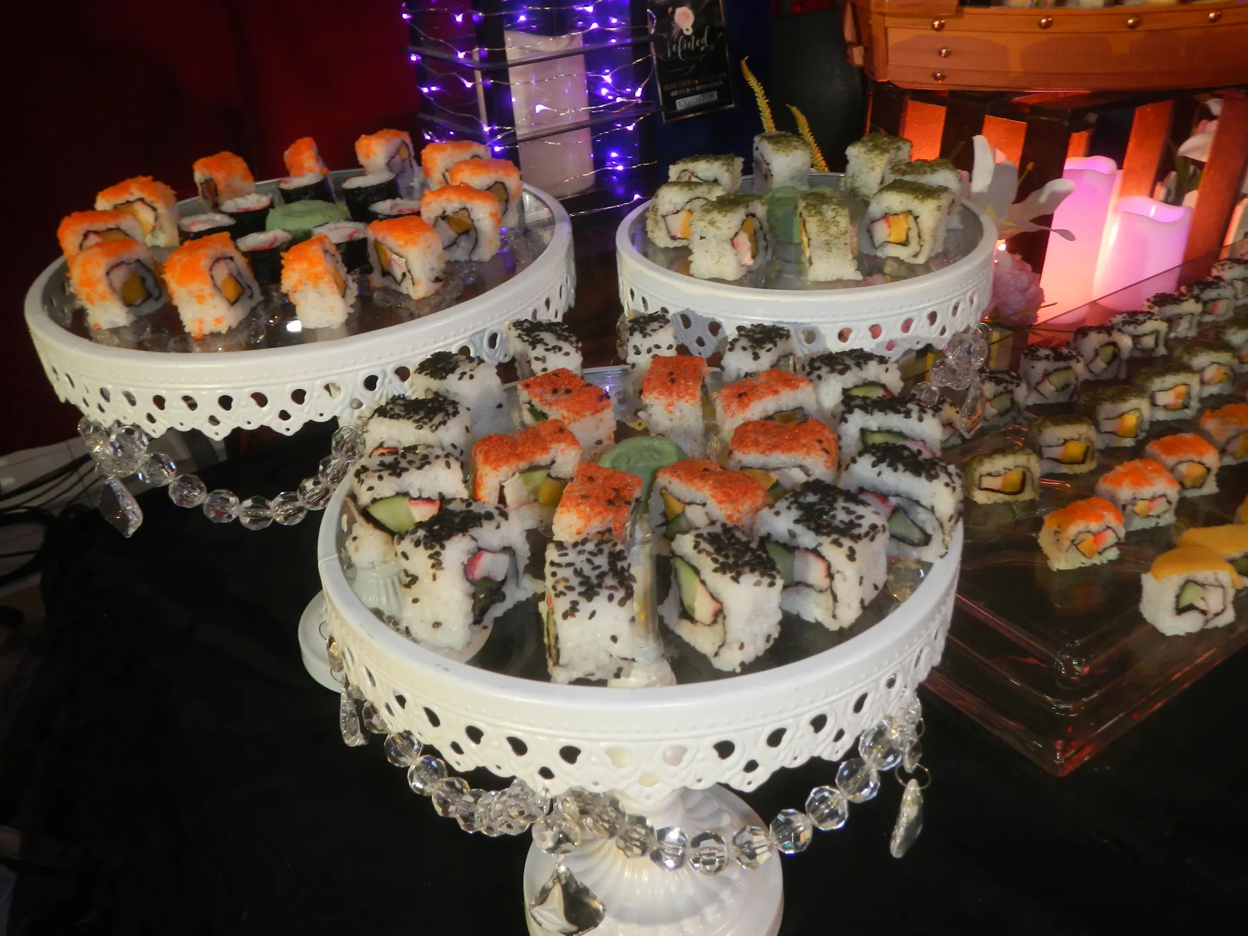 Sushi rolls laid out on tiered white stands