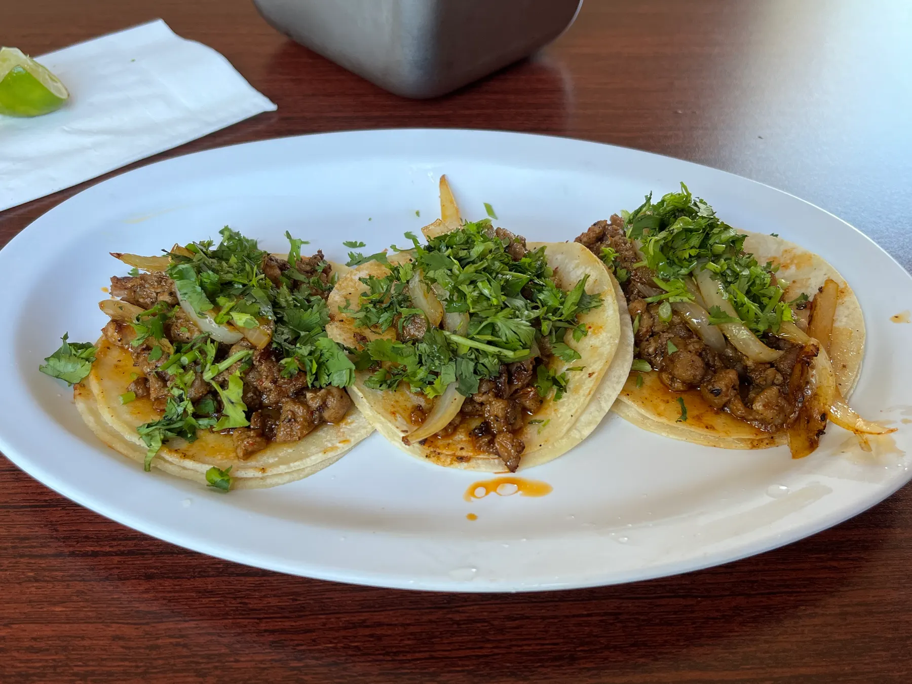 Three soft corn tacos with meat, onion and coriander