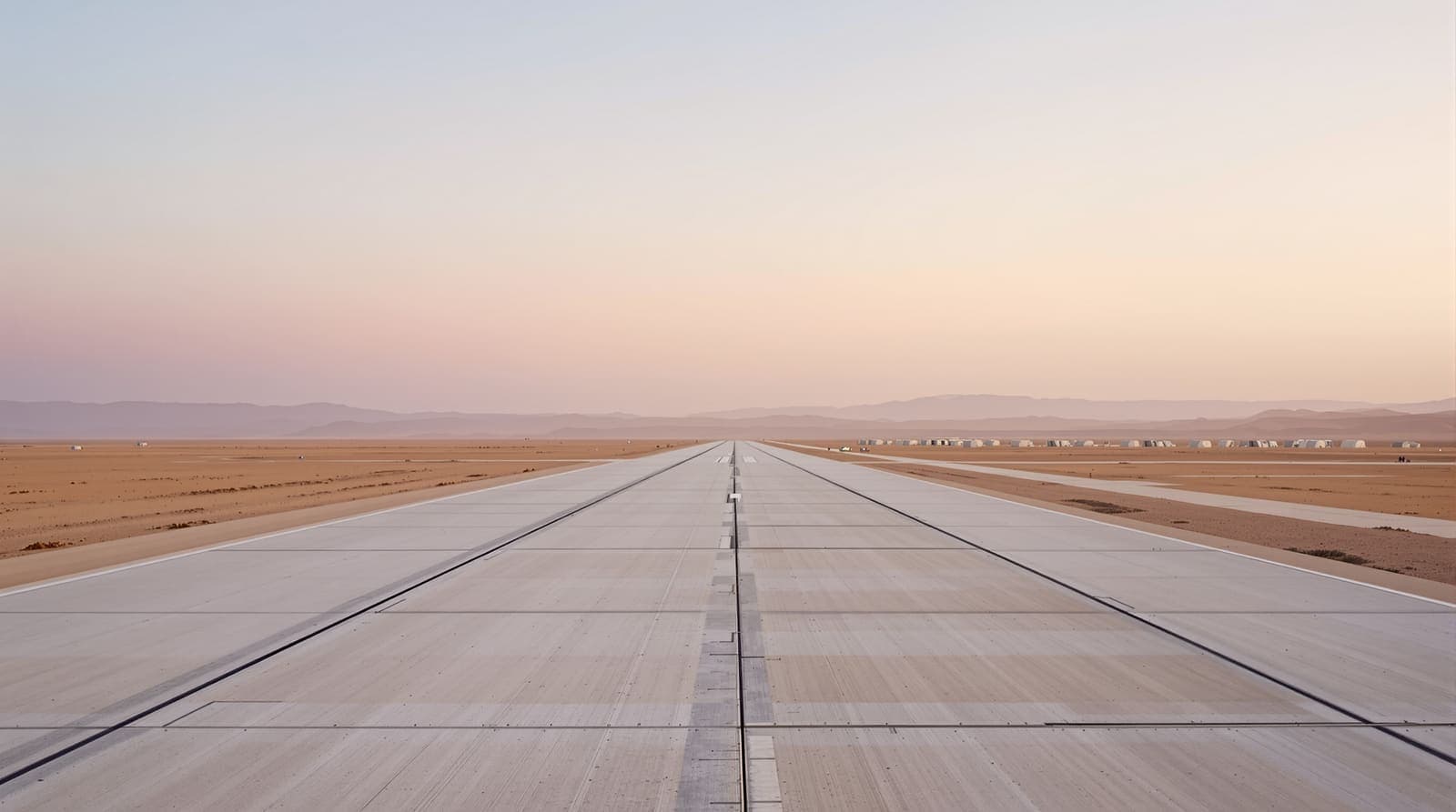 Illustration of an empty desert airbase runway with closed aircraft shelters in the distance at dawn