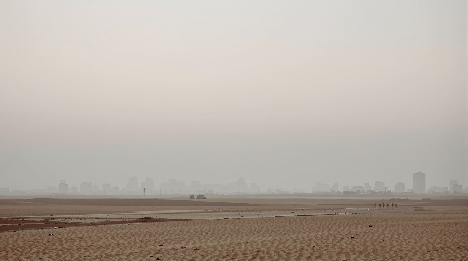 Illustration of the Gaza City skyline seen from a distance across sandy farmland under a hazy dawn sky.