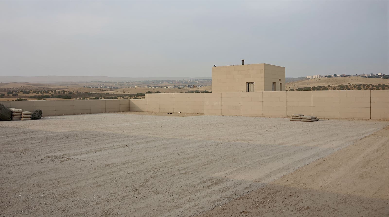 Illustration of a quiet military outpost at dawn near the Gaza border, its yard empty and still.