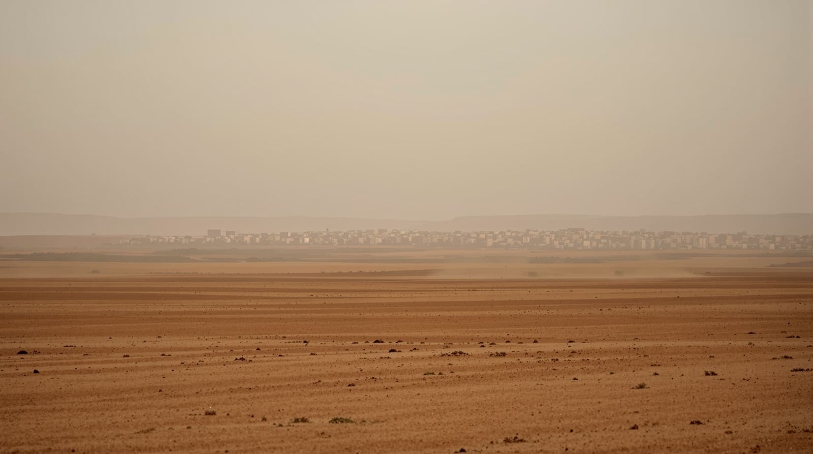 Illustration of the distant northern Gaza skyline seen across dry open fields in hazy dusk light.