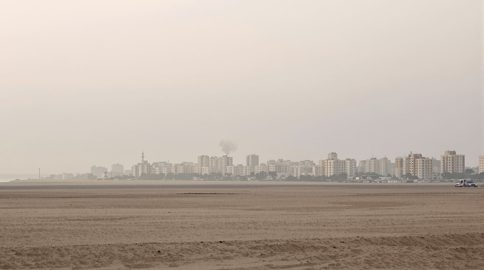 Illustration of the Gaza City skyline in dawn haze, pale apartment blocks seen from a distance near the Mediterranean shore.