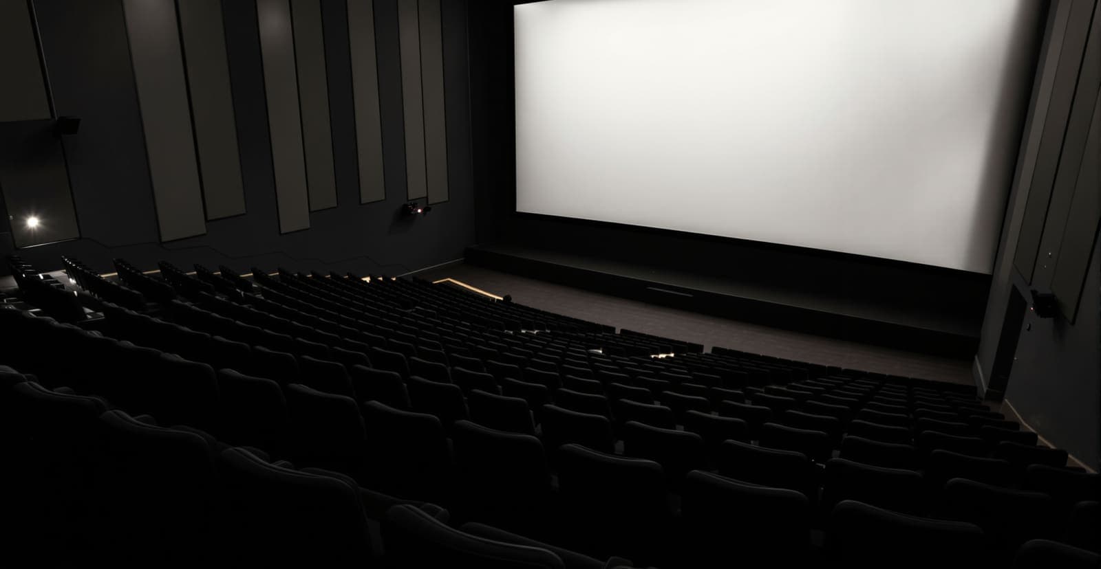 Illustration of an empty cinema auditorium with rows of seats facing a plain blank projection wall in soft house light.