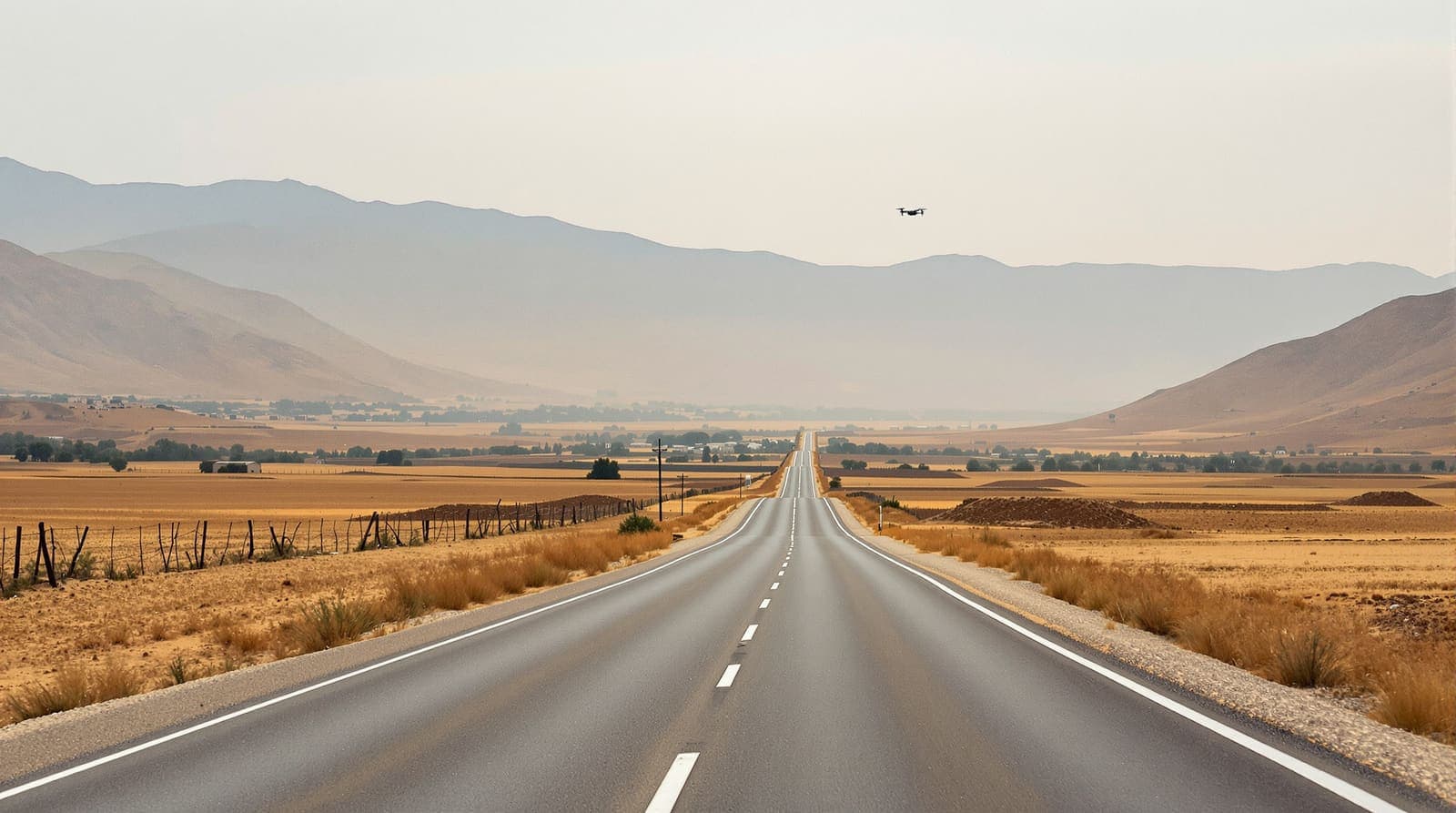 Illustration of an empty rural road through the dry Hermel valley in northeast Lebanon, with bare ridges toward the Syrian border under a pale sky.