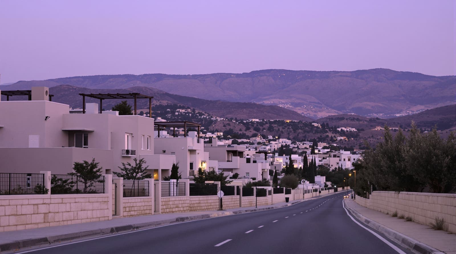 Illustration of an empty residential street of pale stone houses in a northern Israeli Arab town at dusk, hills behind