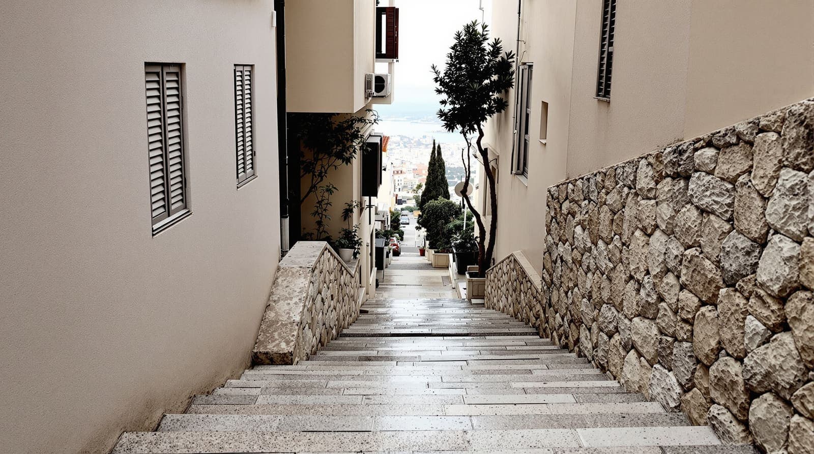 Illustration of an empty stepped stone alley between shuttered hillside apartment buildings in Haifa at overcast dawn.