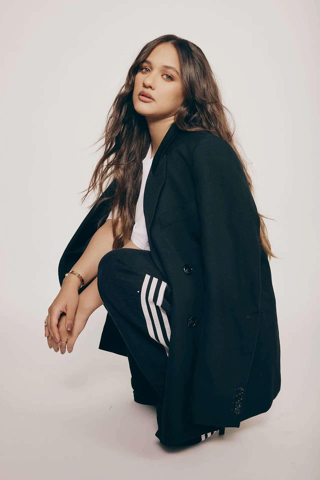 Eden Ben Zaken crouching in a dark tracksuit jacket, 2023