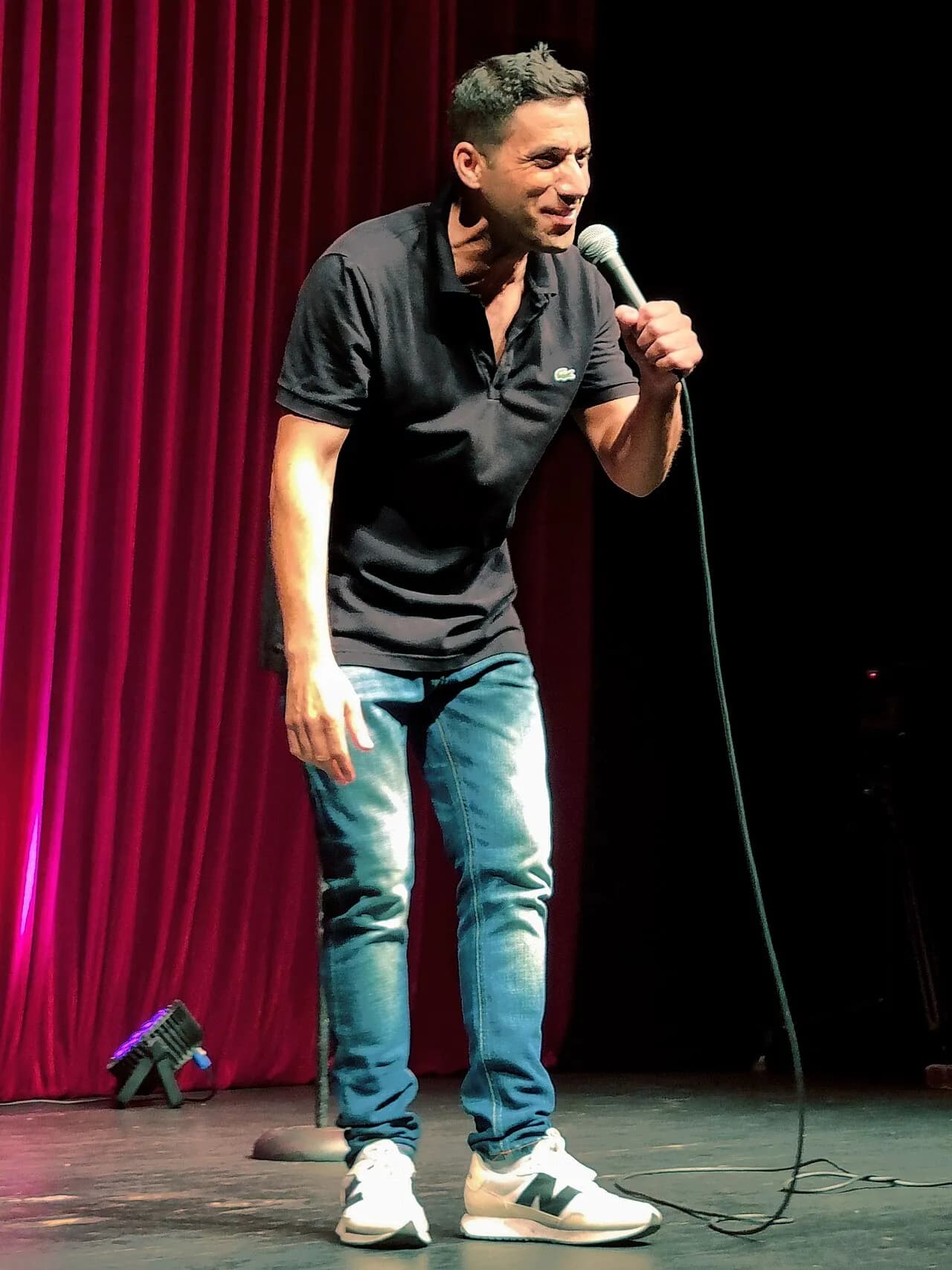 Shahar Hason mid-joke at a stand-up show, 2021