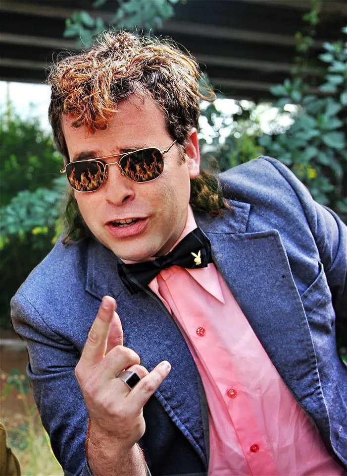 אודי כגן בדמות משיח, במשקפי שמש עם להבות ועניבת פרפר, 2013