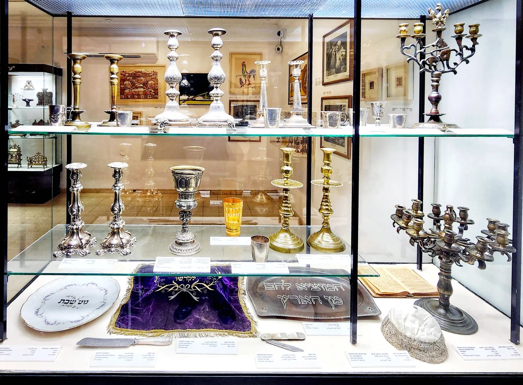 A display case of silver candlesticks, cups and other Judaica at the Bar-David Museum