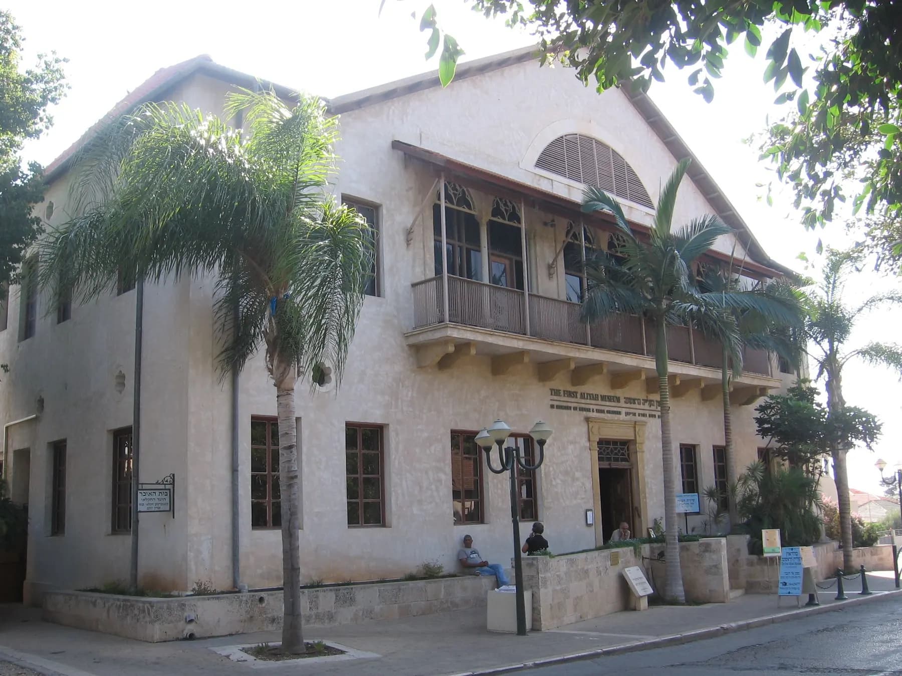 The First Aliyah Museum in Zichron Yaakov, a stone building with a balcony, behind palm trees
