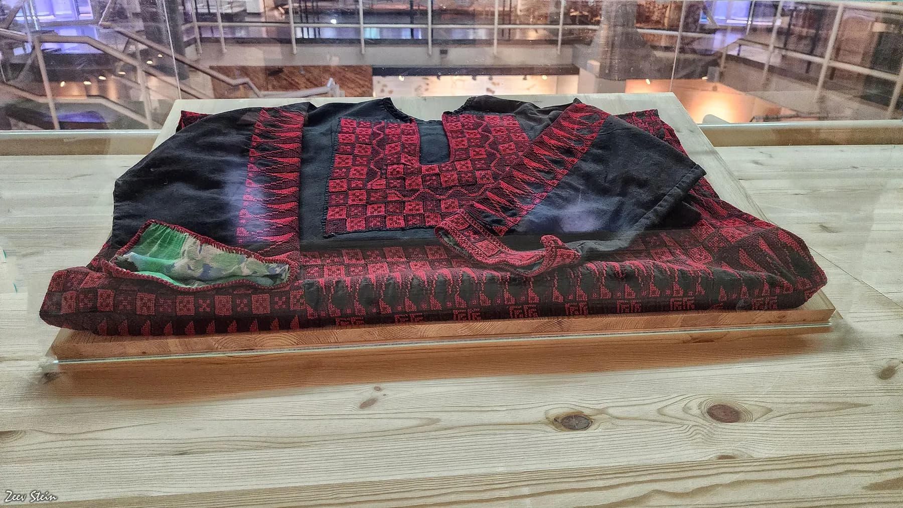 An embroidered Bedouin dress laid out on display in the Joe Alon Center's museum
