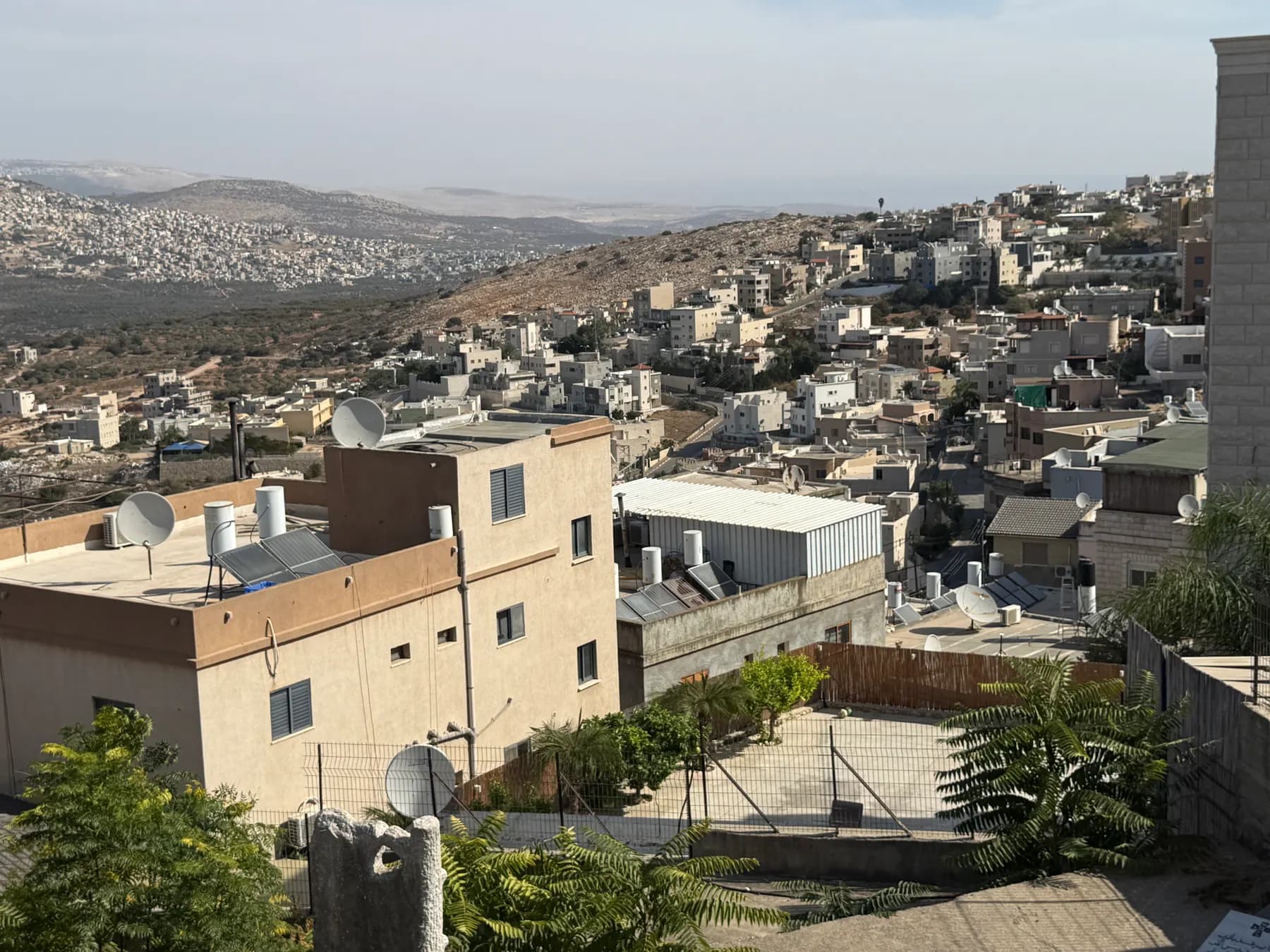 A view over the flat-roofed houses of Deir Hanna, spreading across the hills.