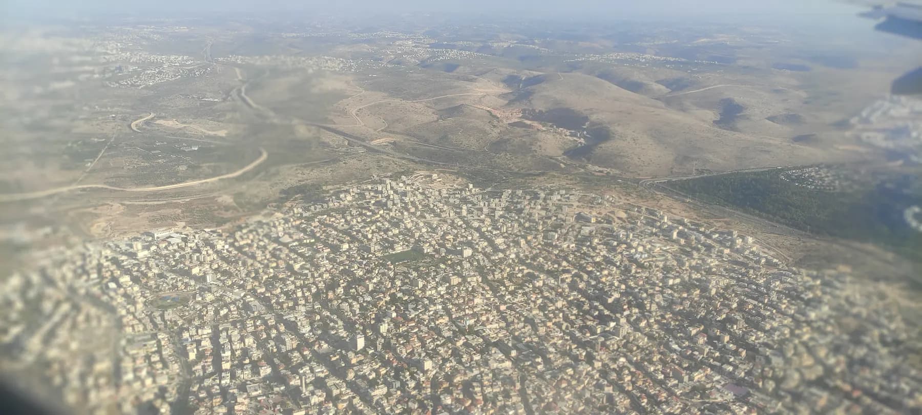 An aerial view of Kafr Qasim, with densely packed houses spreading toward bare hills.