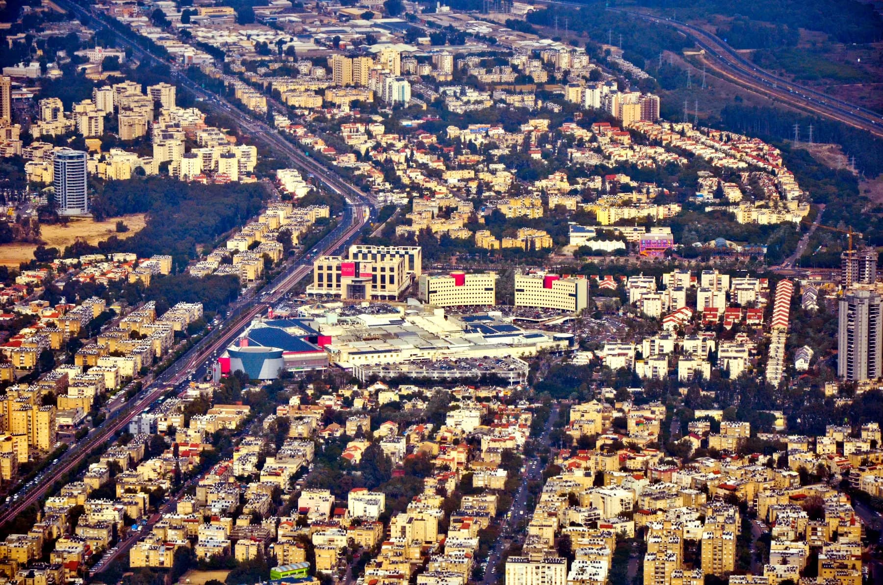 An aerial view of Kiryat Bialik, with the Kiryon shopping mall at the centre and a main road running past it.