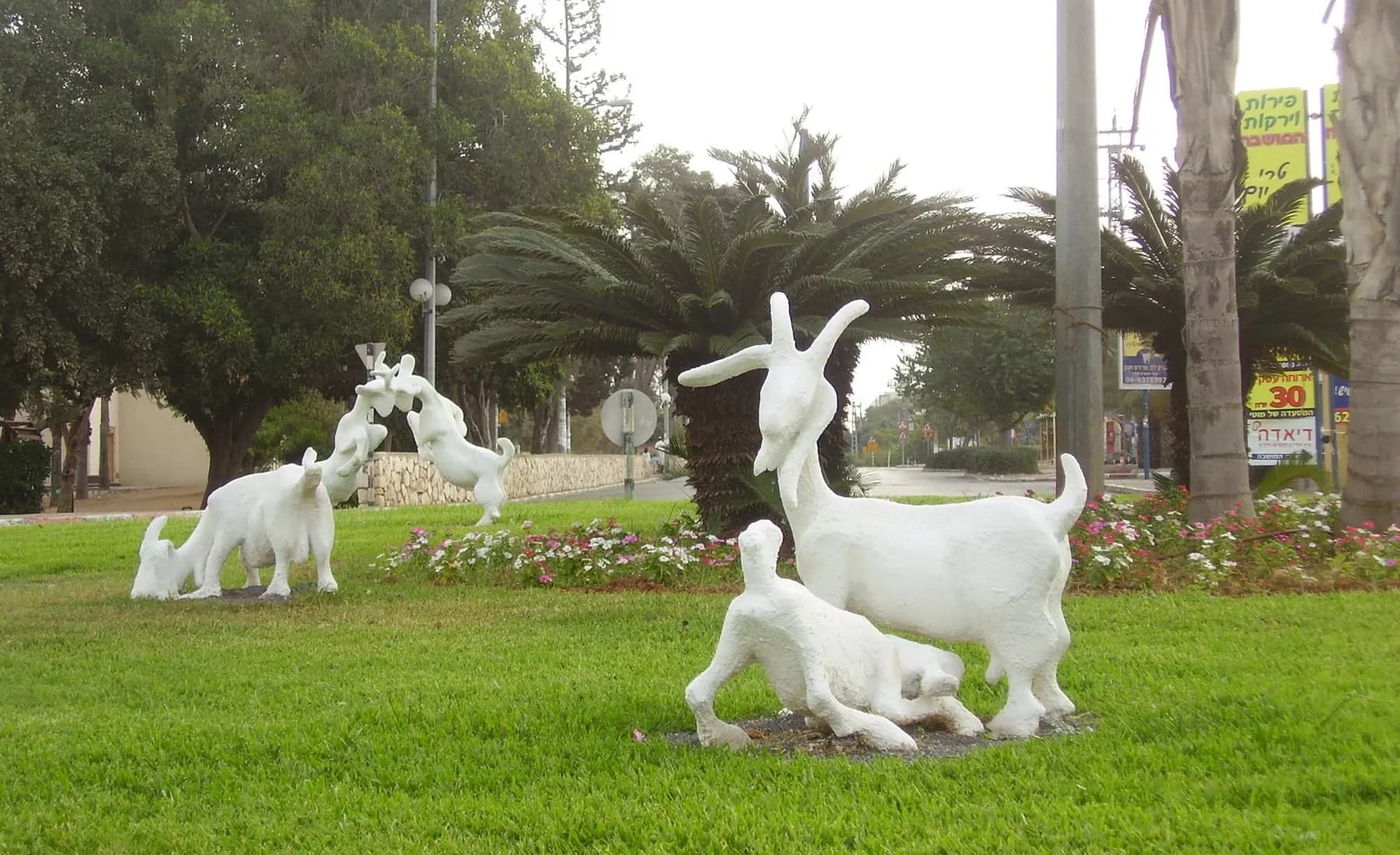 White sculptures of goats on the grass of a traffic circle on Hanadiv road, Pardes Hanna