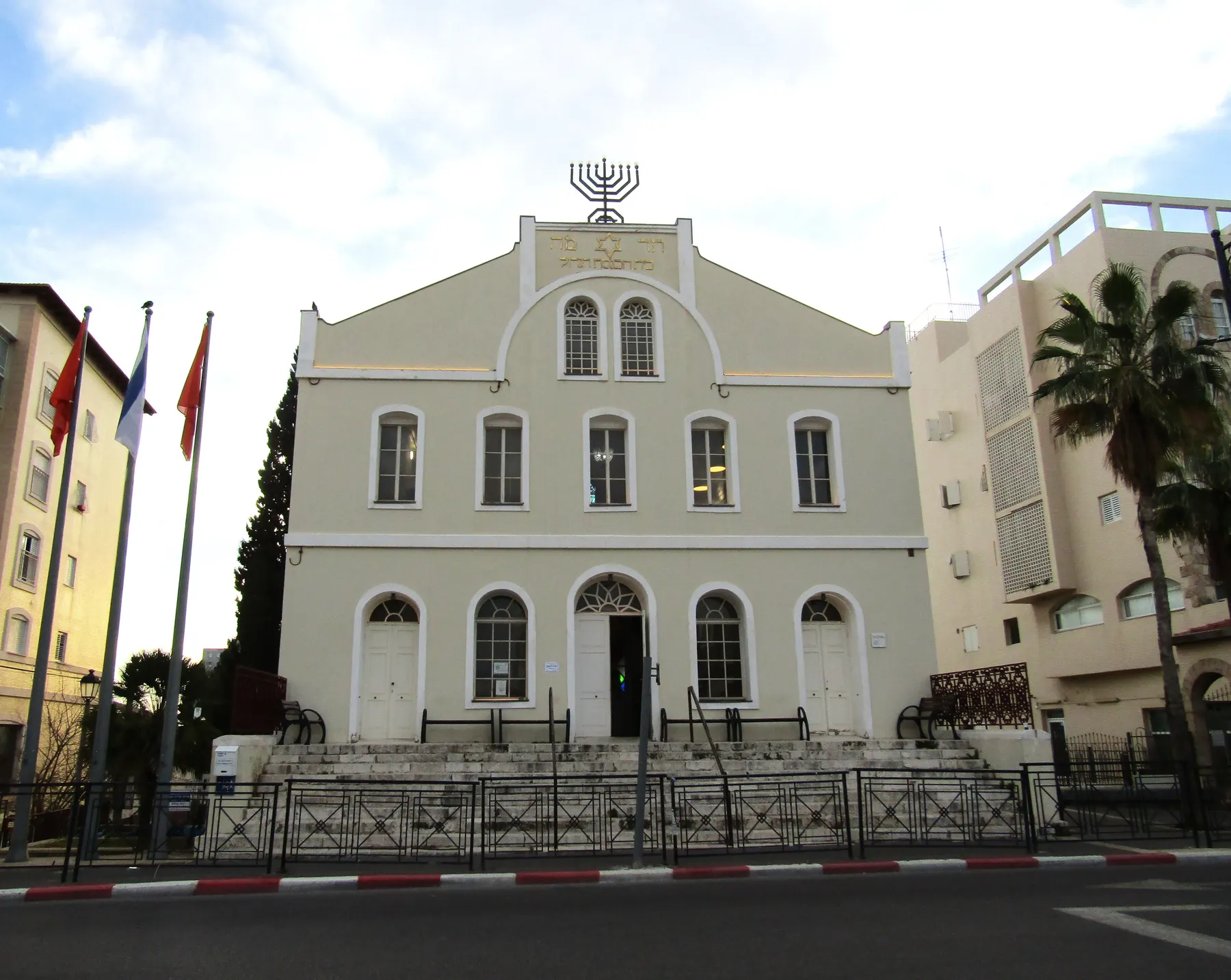The Great Synagogue of Rishon LeZion, a white building of the founders' era with arched windows and a menorah on its gable