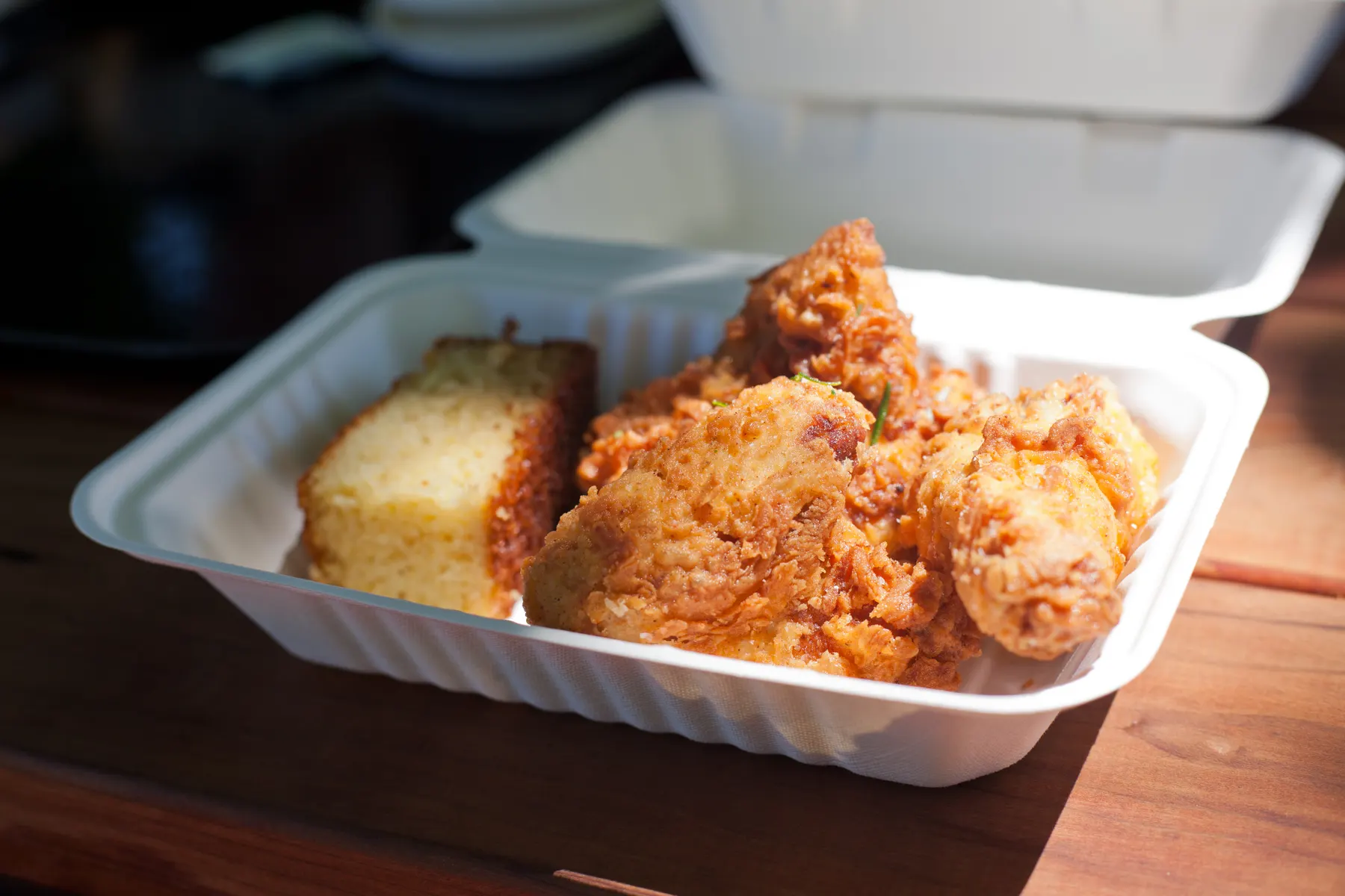 Pieces of fried chicken in a takeaway box.