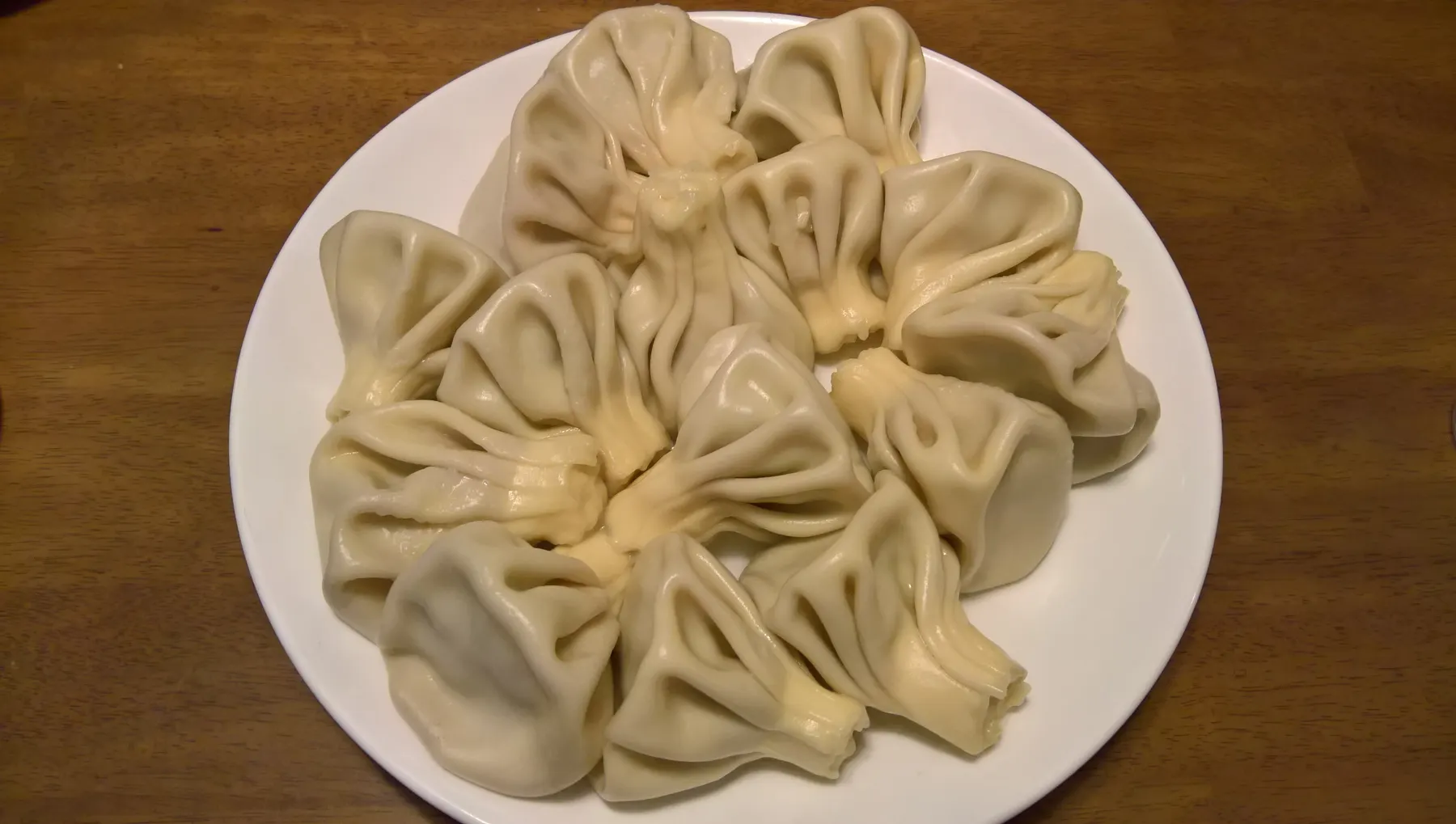 A plate of khinkali, Georgian dumplings gathered into a twisted knot at the top