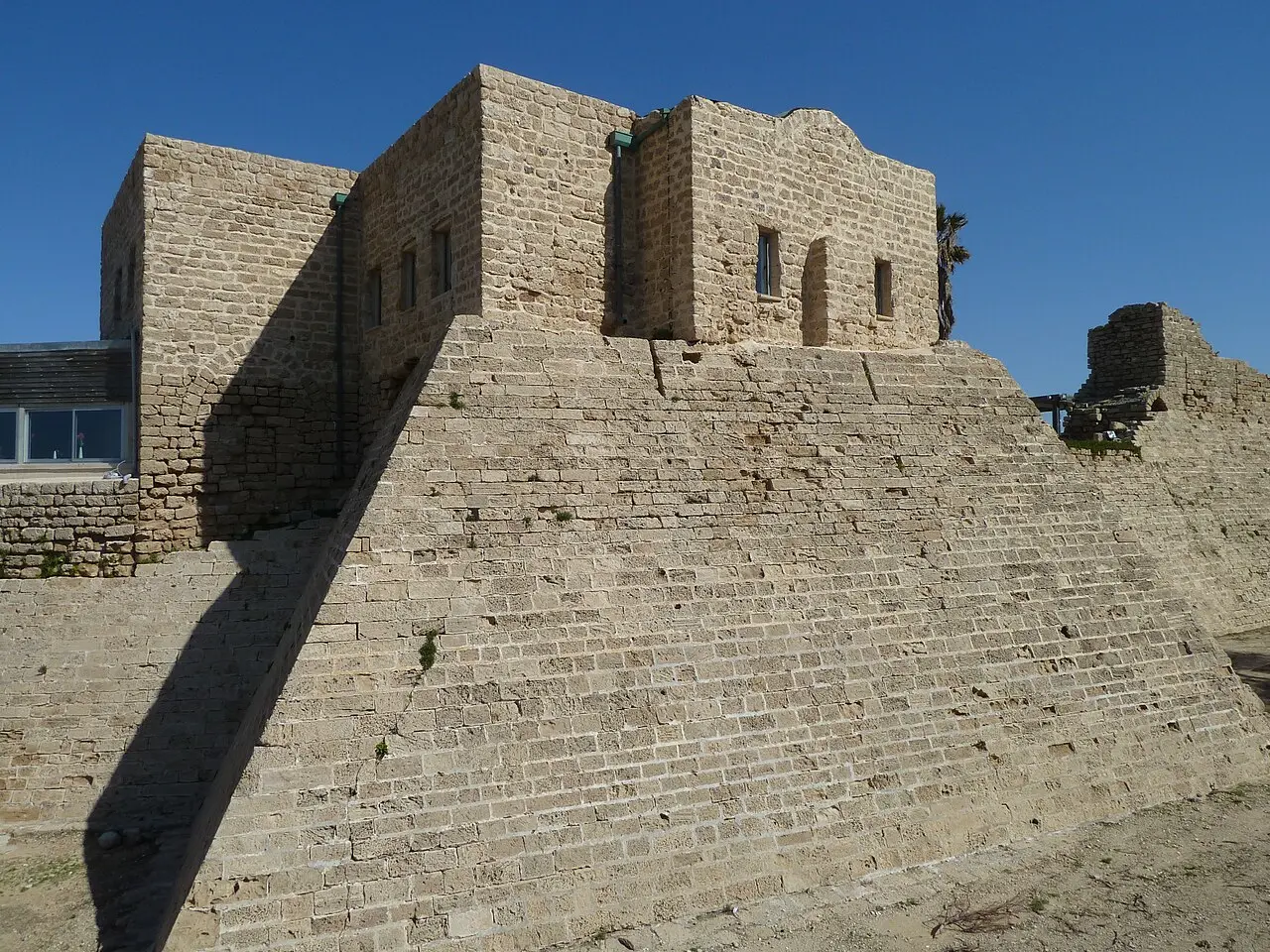 A tower of Caesarea's Crusader wall rising from its sloping stone base