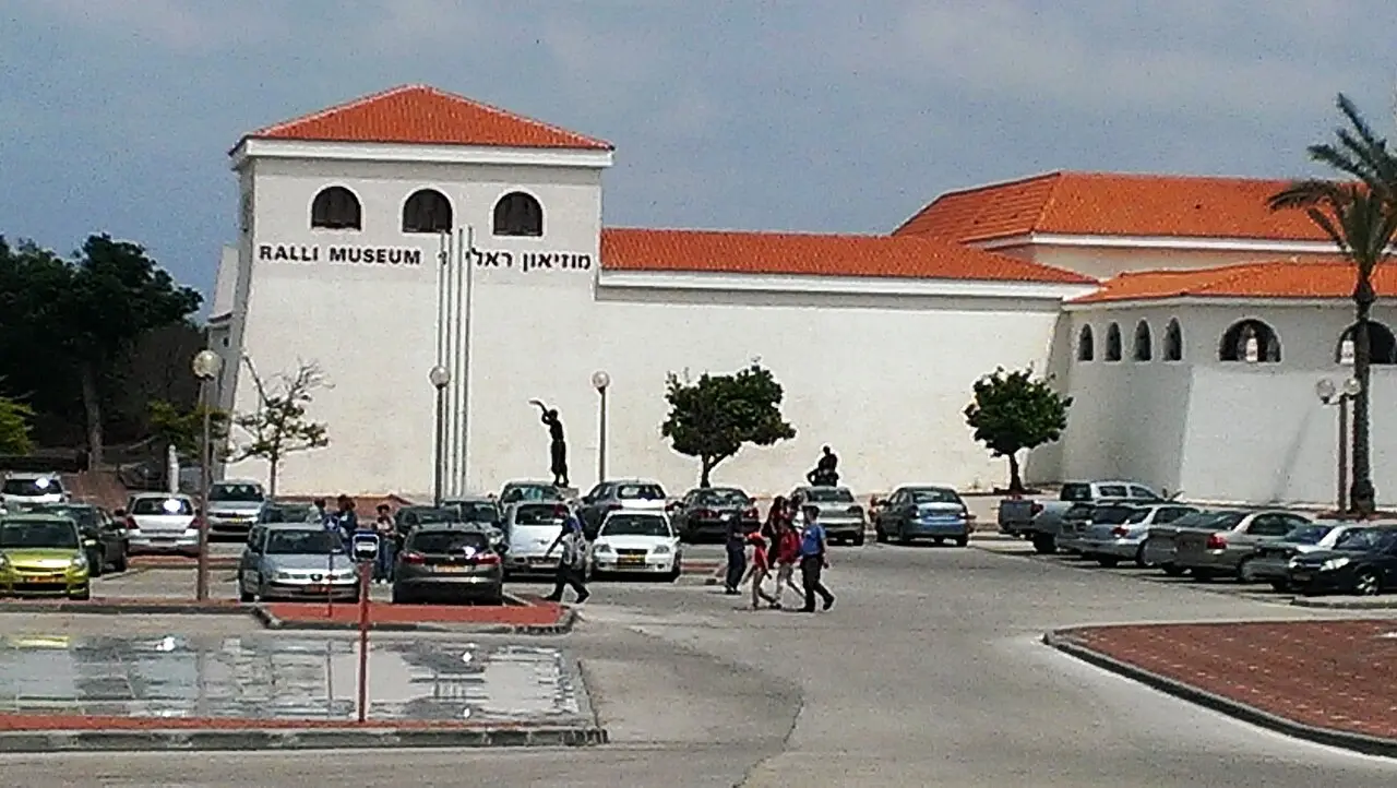 The white walls and red tile roofs of the Ralli Museum in Caesarea, seen across its car park