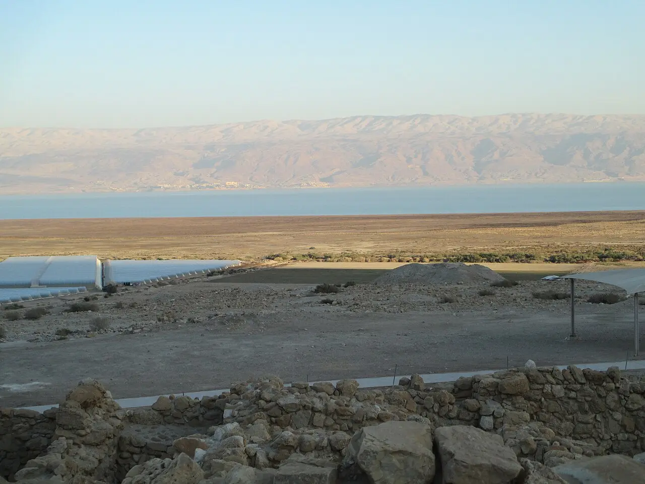 Low excavated walls at Qumran, the Dead Sea and the hills of Jordan beyond