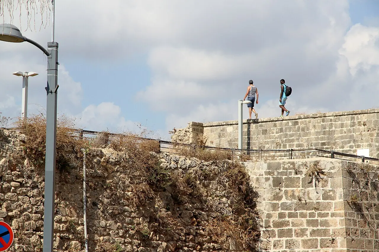 People walking along the top of Acre's sea wall