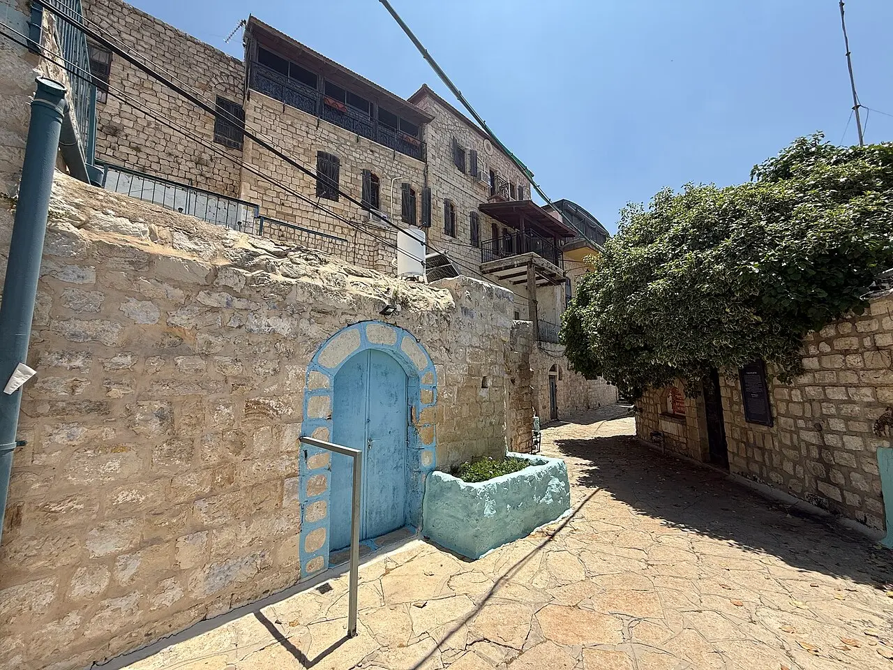 A cobbled alley in Safed's Old City, a blue-painted door in its stone wall