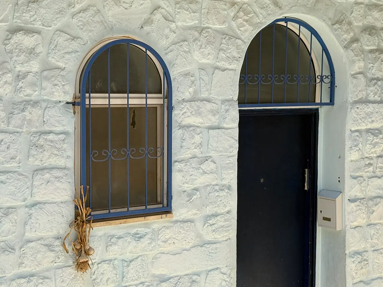 A whitewashed house front with blue window frames in Safed's Old City