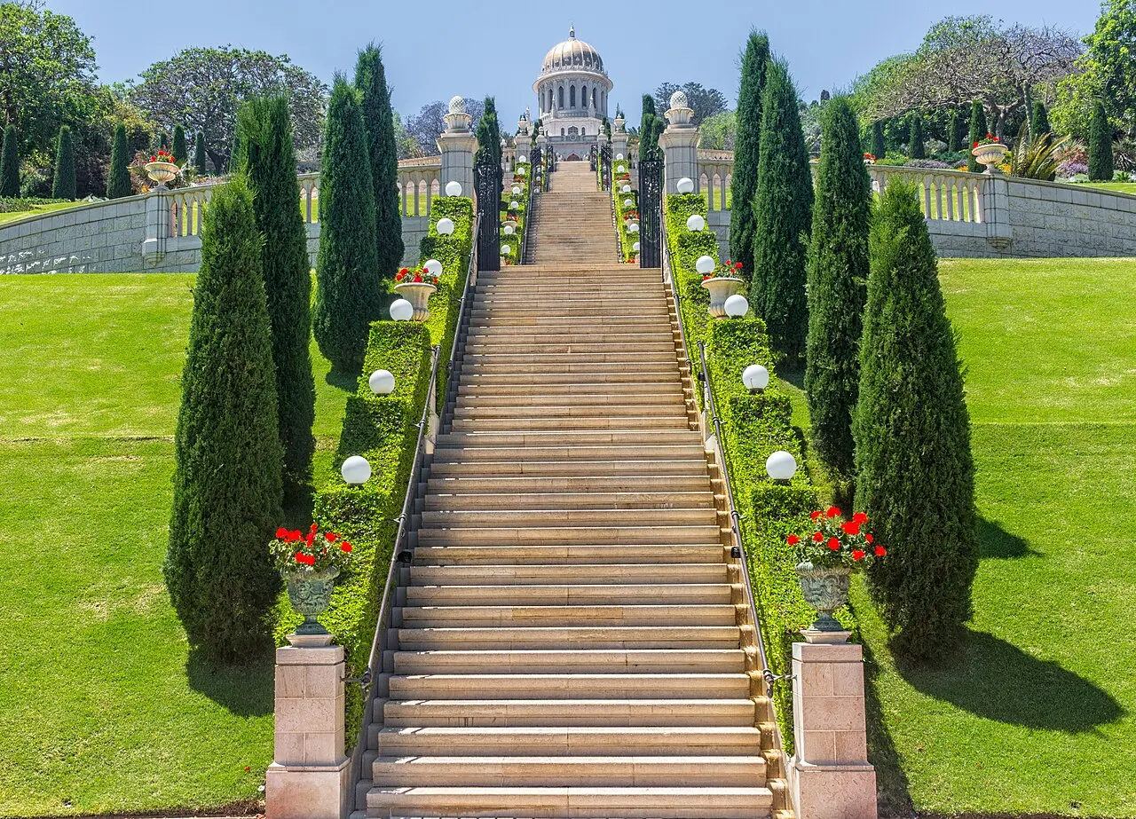 A flight of steps climbing the terraces between cypresses, the shrine's dome at the top