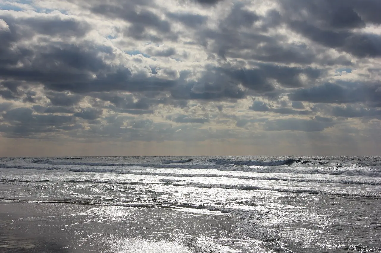 Surf rolling in under a grey sky at Dado Beach
