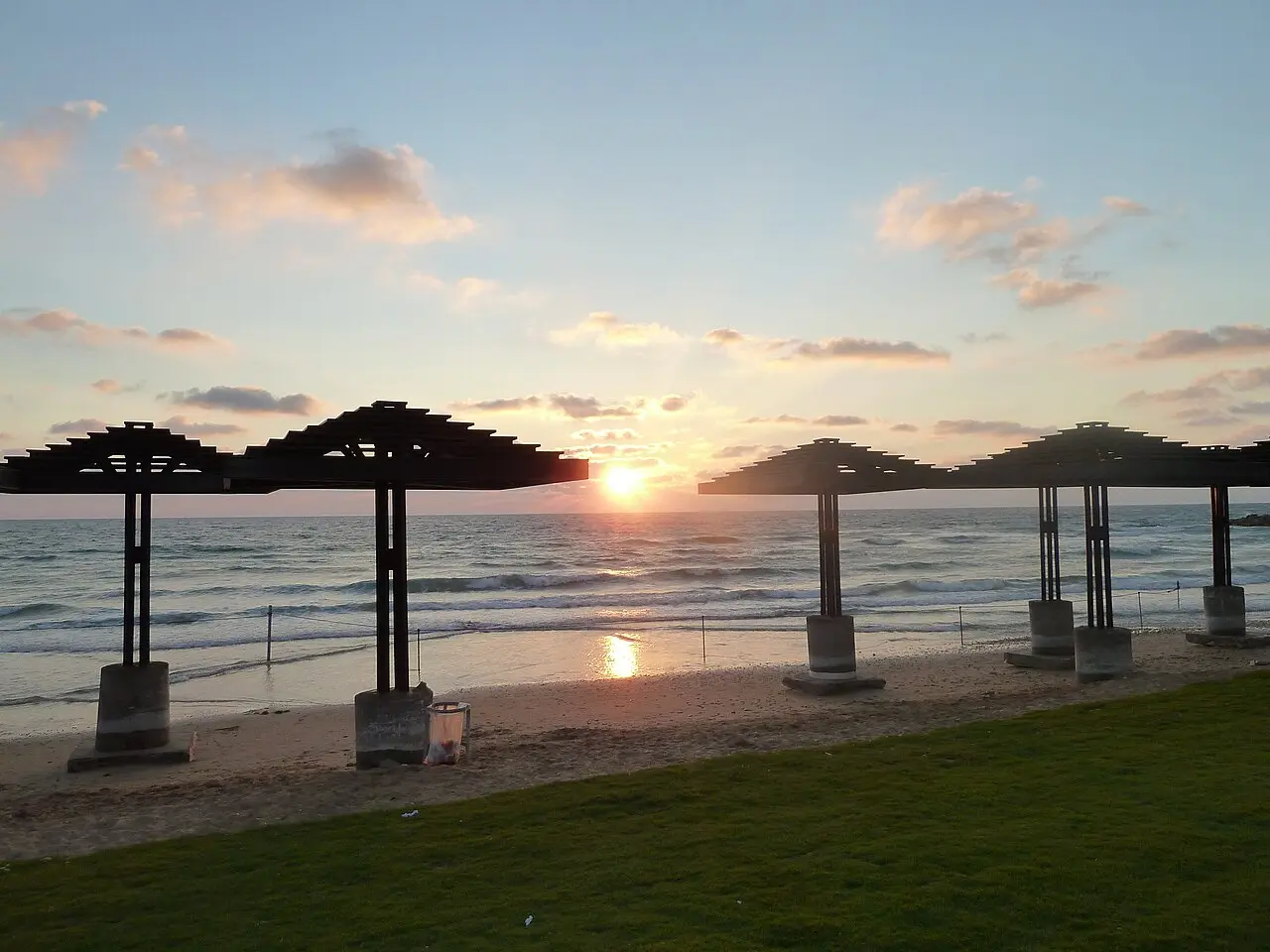 Sunset behind the shade pavilions at Dado Beach